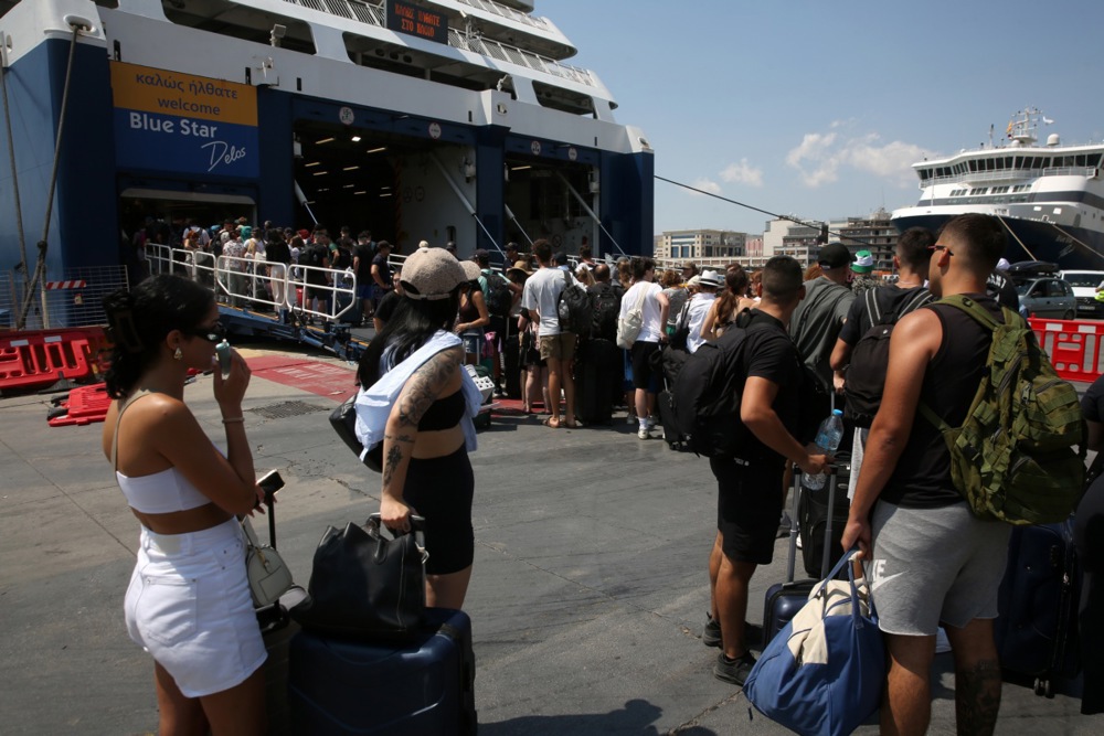epa12289743 Travelers queue to board a ferry where they will wait for departure from the port of Piraeus, Greece, 08 August 2025. Ferries will remain docked at the ports of Piraeus, Lavrio, and Rafina on 08 August as a sailing ban has been extended due to the gale-force winds blowing in the Aegean. However, certain routes are being operated, following decisions by ferry companies, as provided for. EPA/ALEXANDROS BELTES