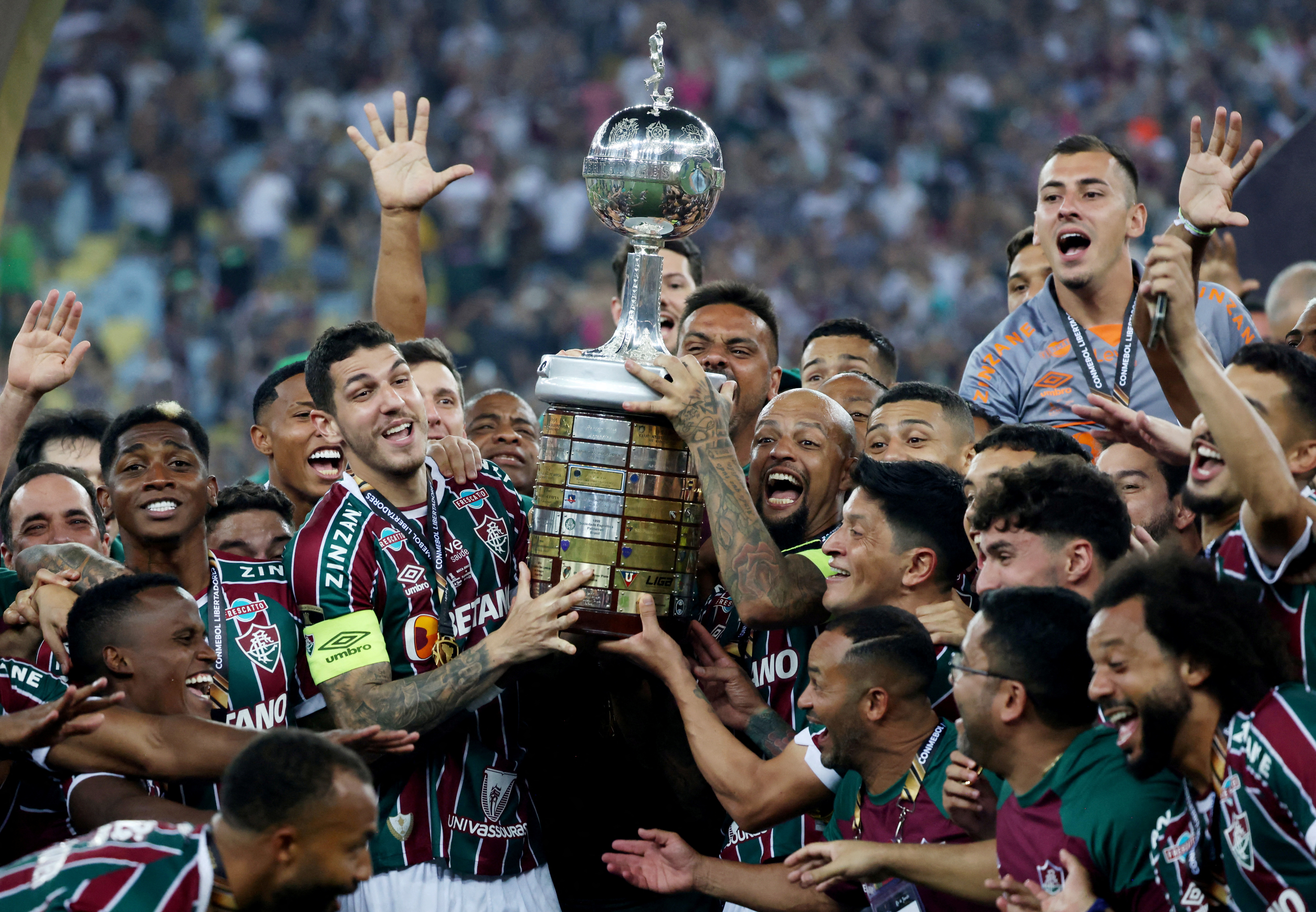 Fabio, right, watches on as Fluminense's Nino and Felipe Melo lift the trophy as they celebrate with teammates after winning the Copa Libertadores