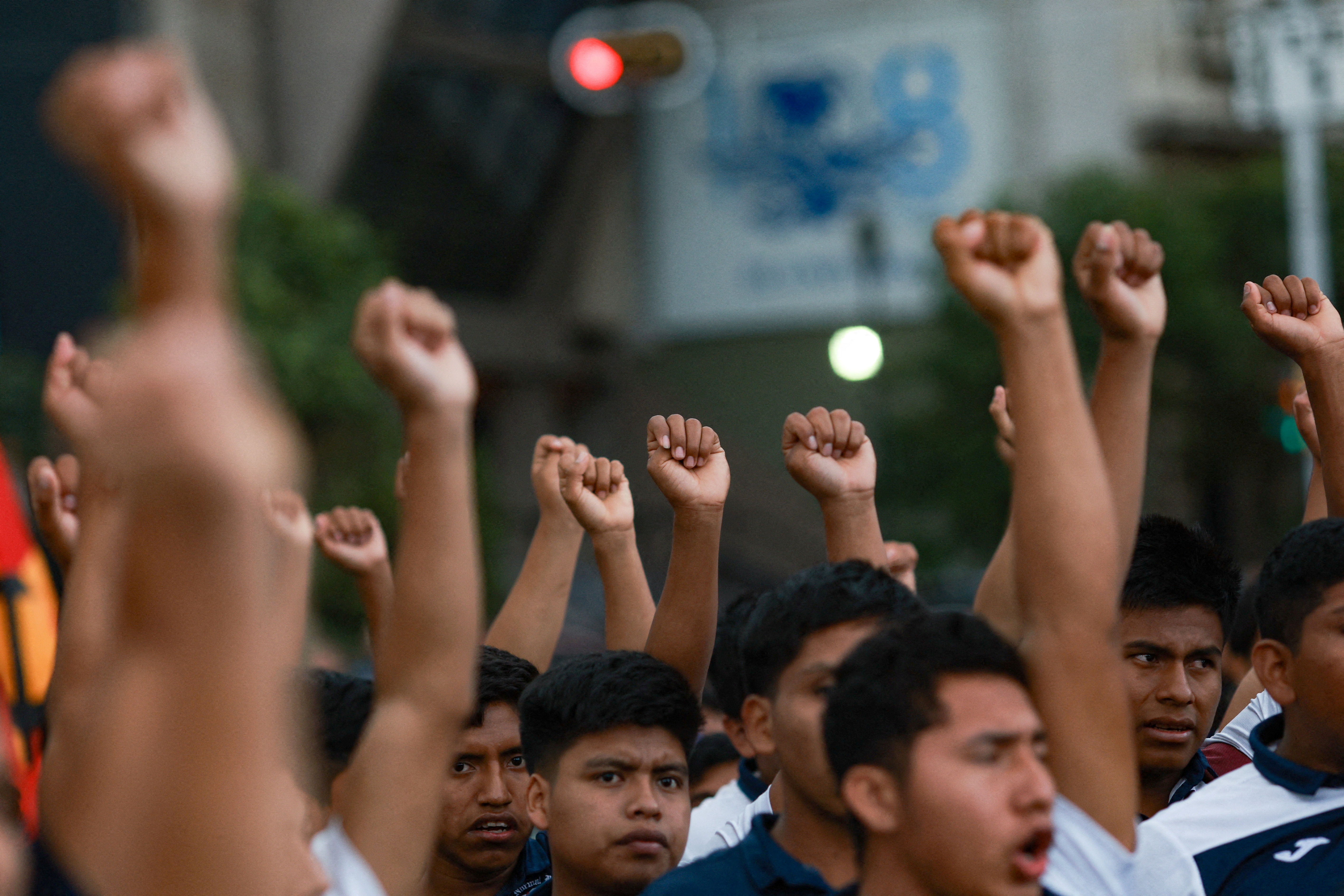 Young men raise their fists in the air as part of a protest.