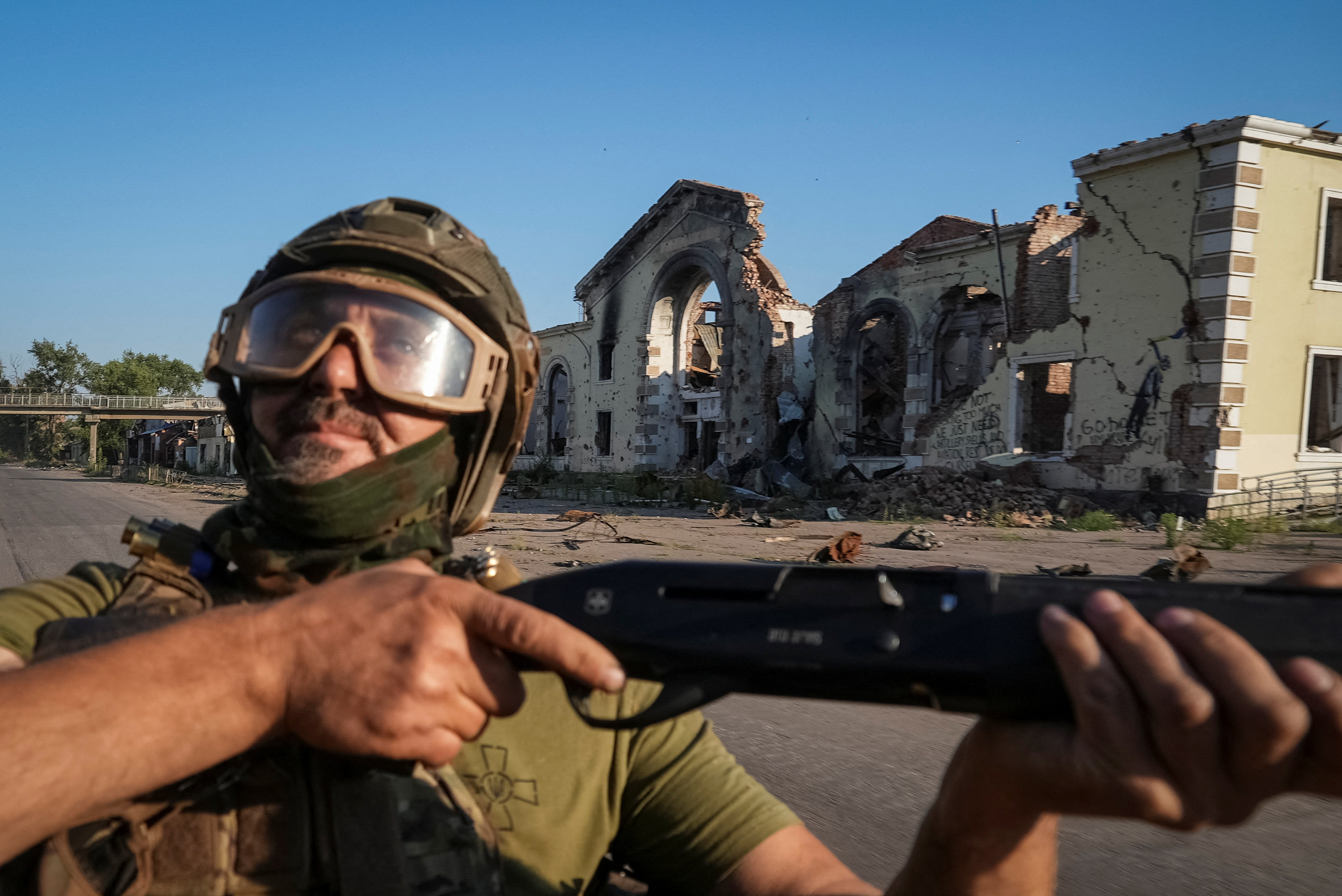 A serviceman of the 93rd Kholodnyi Yar Separate Mechanized Brigade of the Ukrainian Armed Forces holds a shotgun as he looks up to check for Russian combat drones, amid Russia's attack on Ukraine, in the frontline city of Kostiantynivka in Donetsk region, Ukraine July 31, 2025. REUTERS/Inna Varenytsia