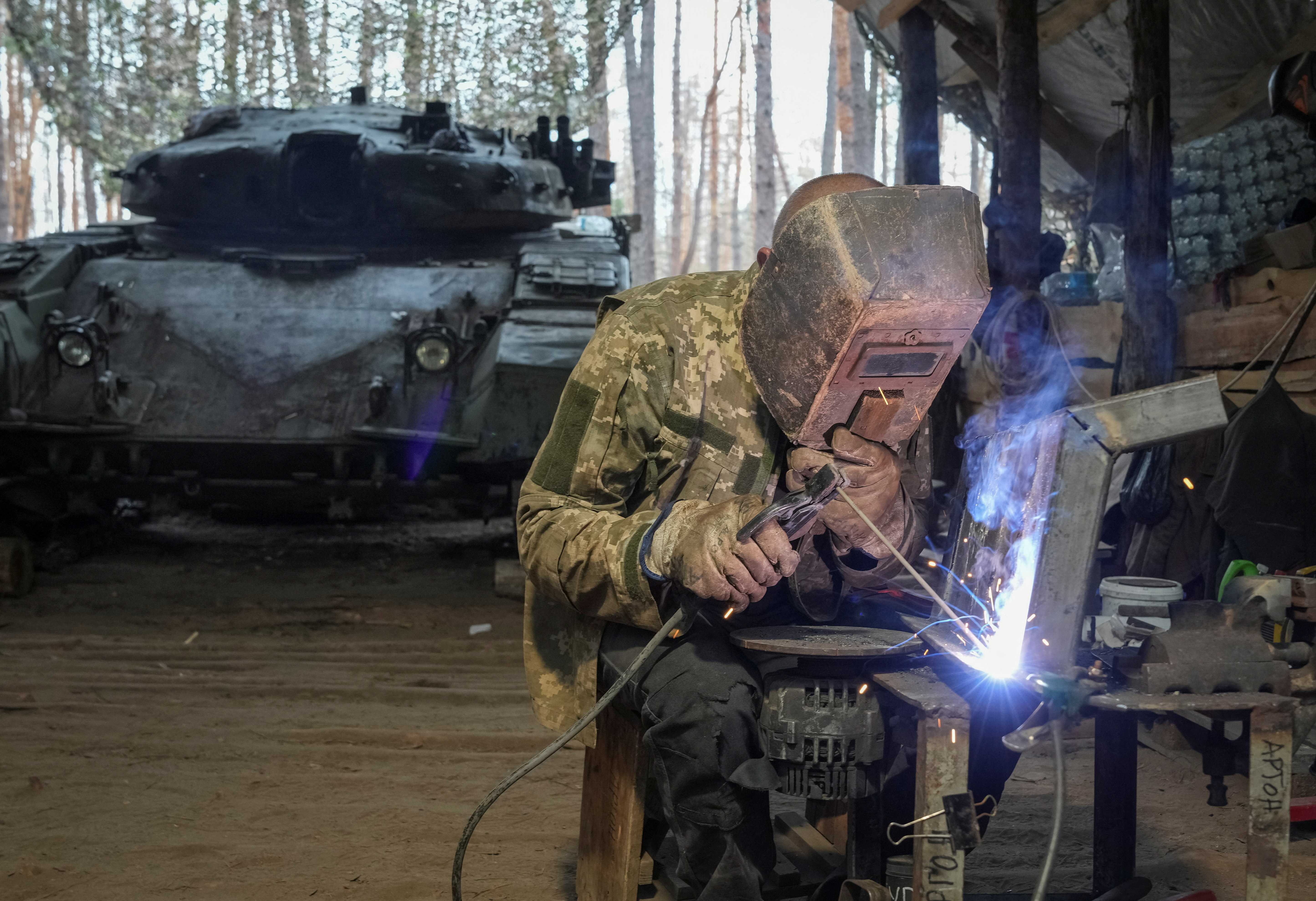 A serviceman of the 57th Separate Motorized Infantry Brigade of the Armed Forces of Ukraine repairs a tank, amid Russia's attack on Ukraine, in Kharkiv region, Ukraine August 1, 2025. REUTERS/Inna Varenytsia