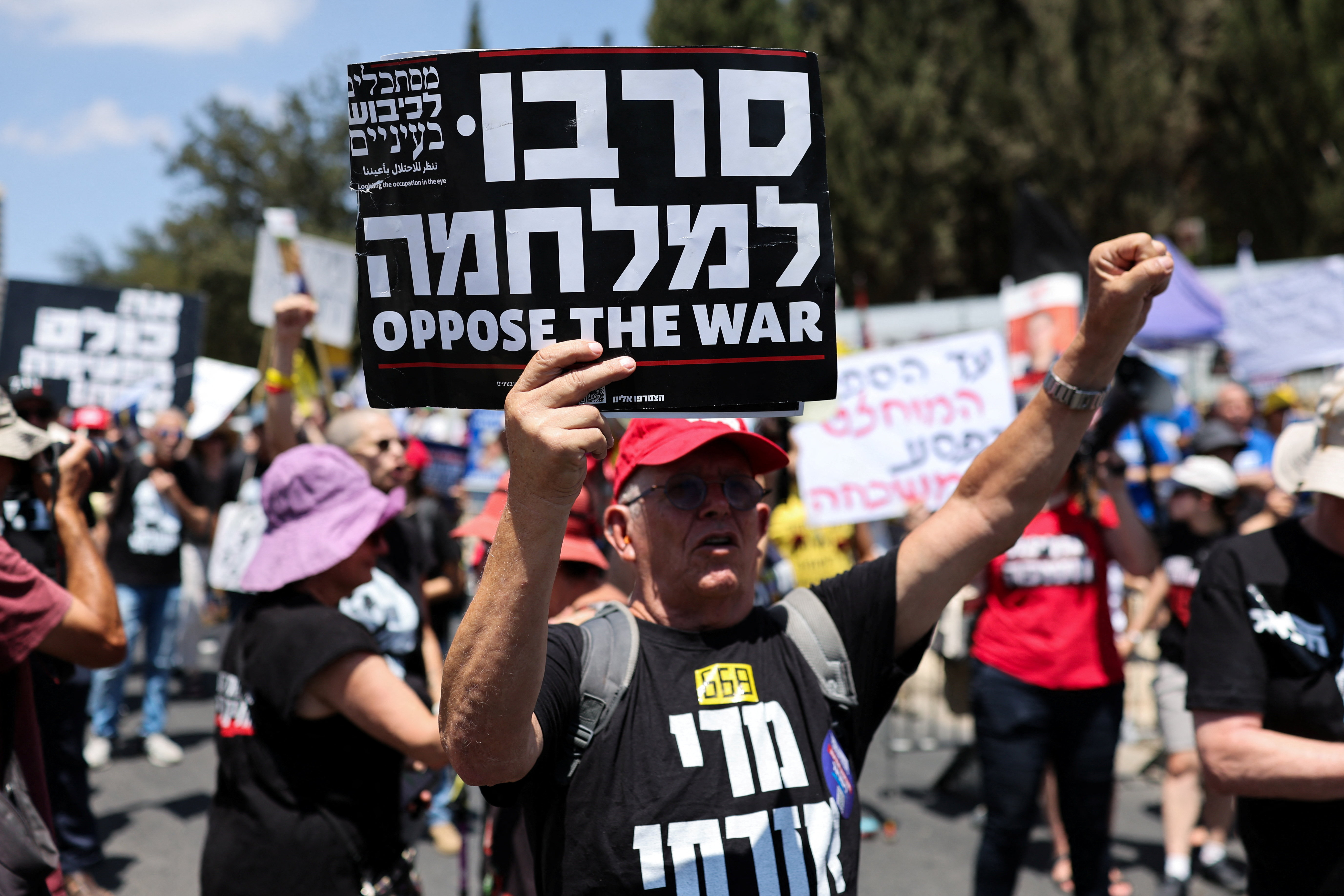 A demonstrator holds a placard, as people protest in support of Israeli Attorney General Gali Baharav-Miara, and to demand the end of the war in Gaza and release of all hostages, outside Israeli Prime Minister Benjamin Netanyahu's office in Jerusalem August 4, 2025. REUTERS/Ronen Zvulun