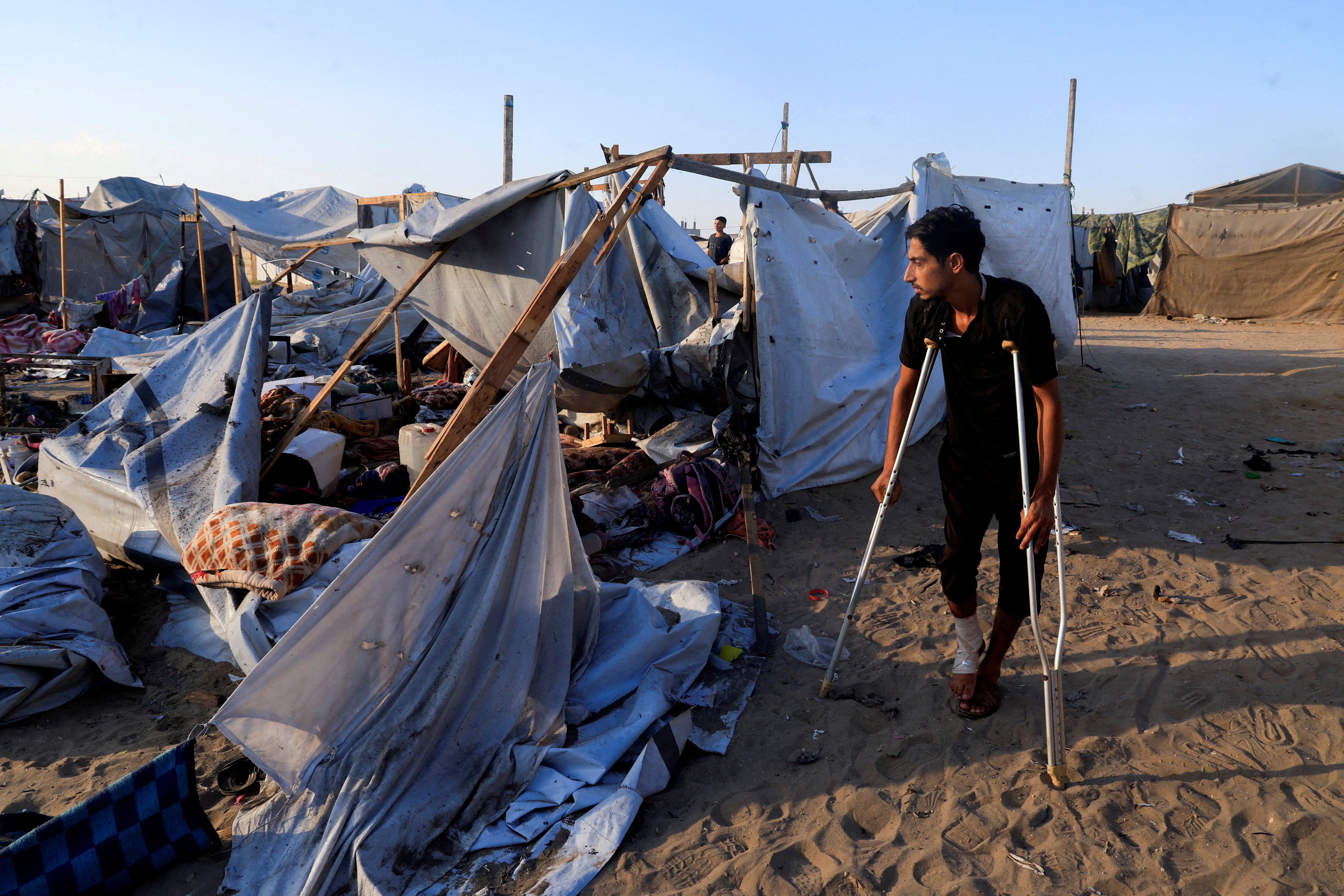 Palestinians inspect the damage at the site of an overnight Israeli strike on a tent sheltering displaced people, in Khan Younis, southern Gaza Strip, August 5, 2025. [Hatem Khaled/Reuters]