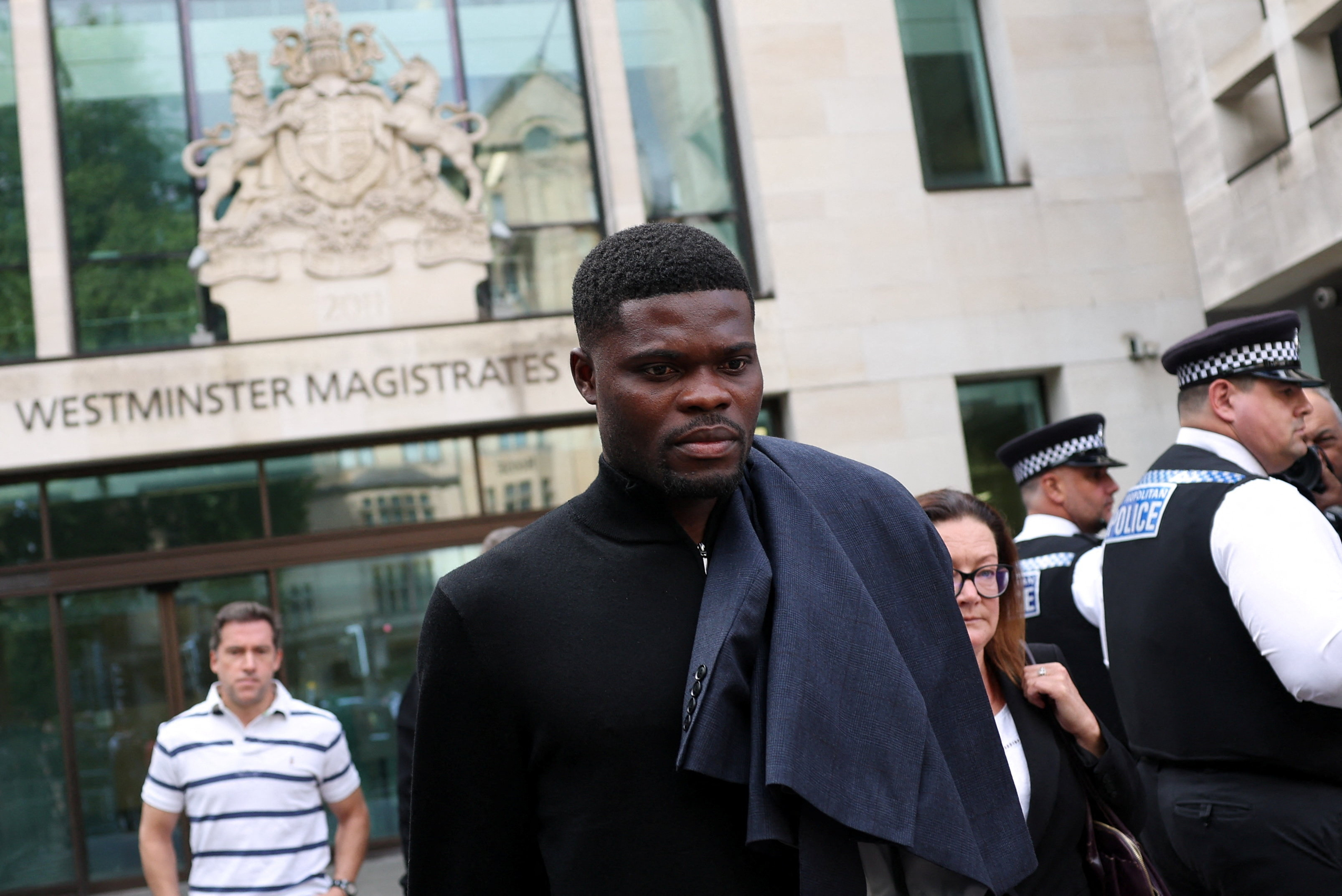 Former Arsenal player Thomas Partey, who has been charged with five counts of rape and one count of sexual assault, walks outside Westminster Magistrates' Court, in London