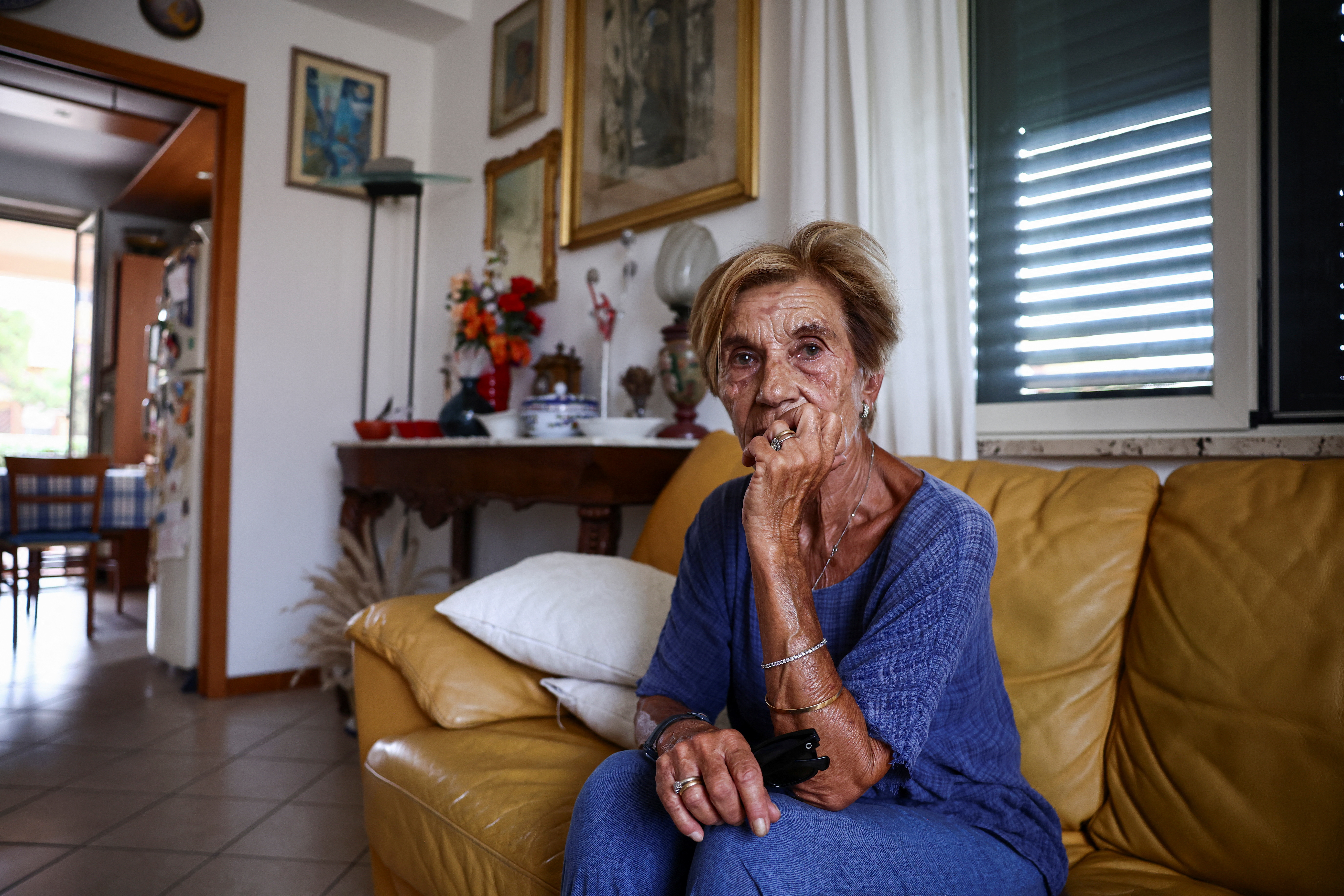 Mariolina De Francesco, 75, sits on a sofa in her house, during an interview with Reuters in Messina, Italy, August 5, 2025. Construction of the suspension bridge connecting Sicily to mainland Italy is expected to be completed by 2032. REUTERS/Yara Nardi