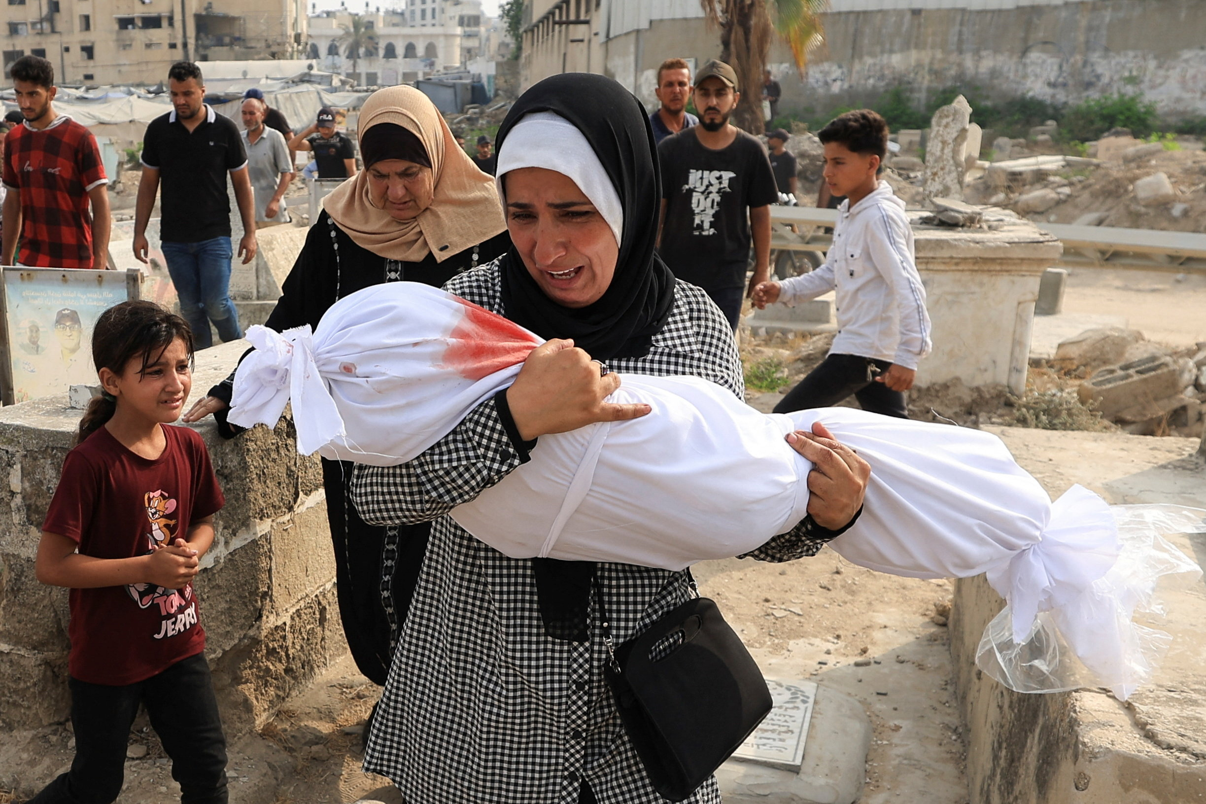 Palestinian woman Soha Tafesh carries the body of her granddaughter Sarah Abu Daf,