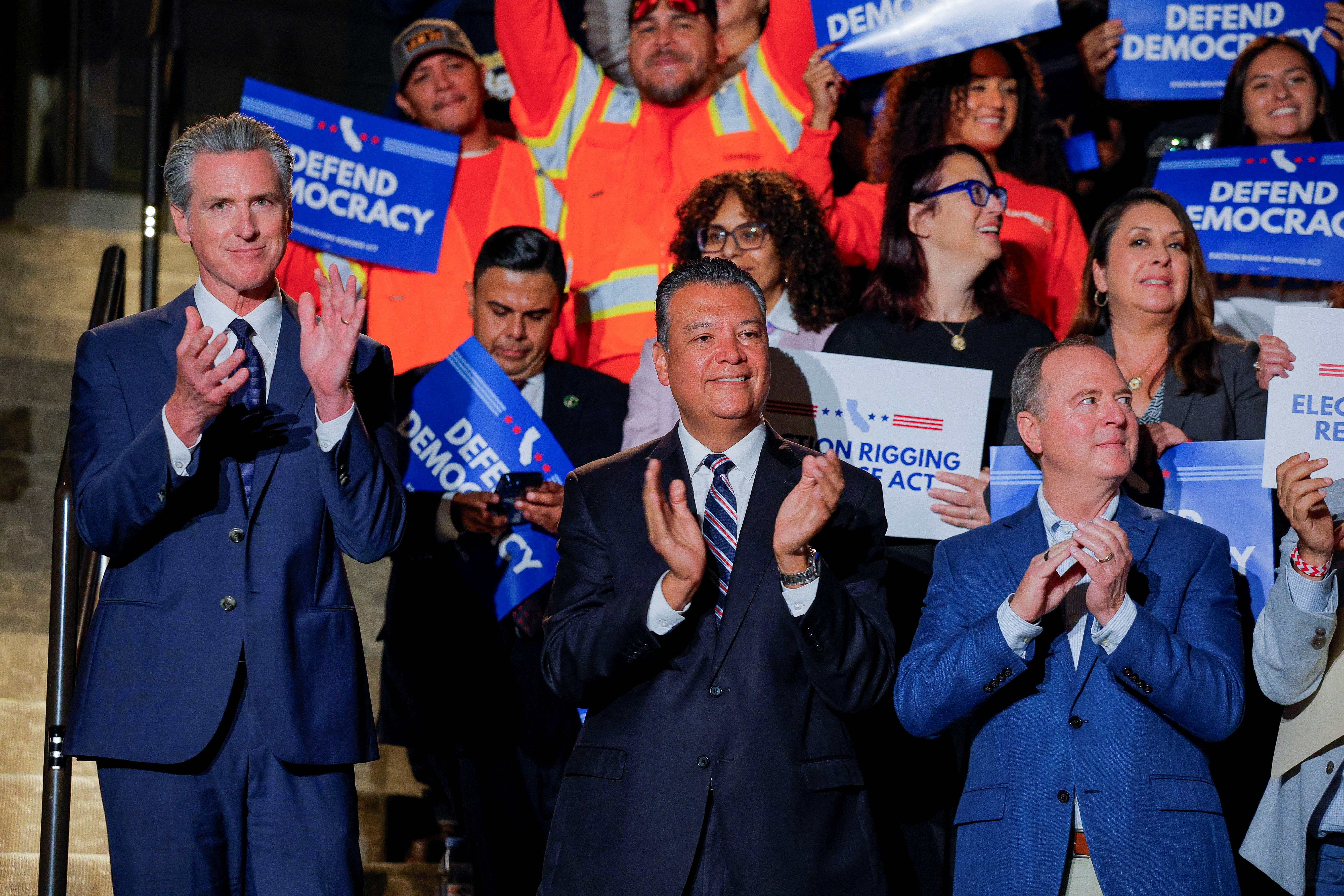 Gavin Newsom applauds during remarks