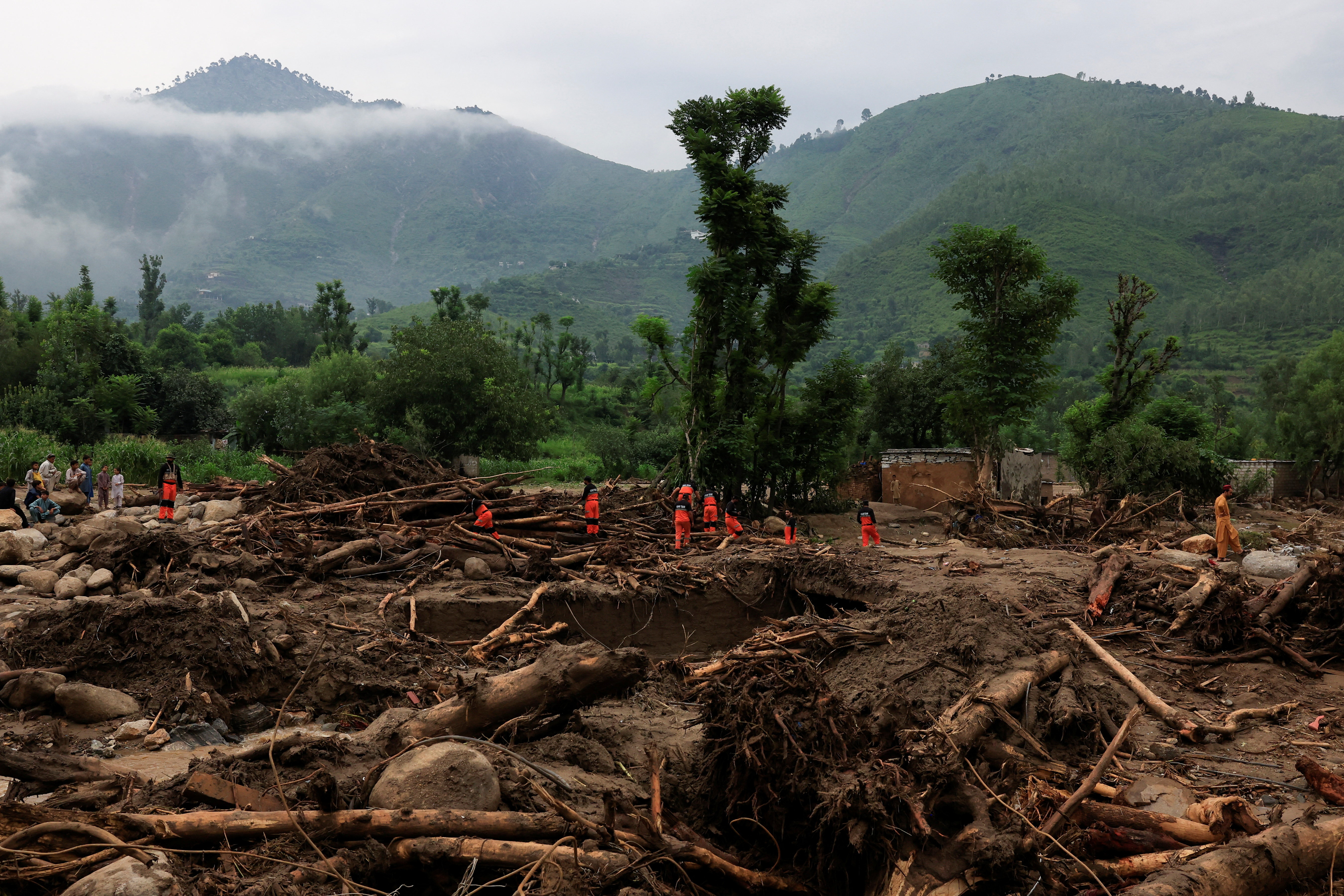 Members of the Urban Search and Rescue search for the bodies amid debris of damaged houses following a storm