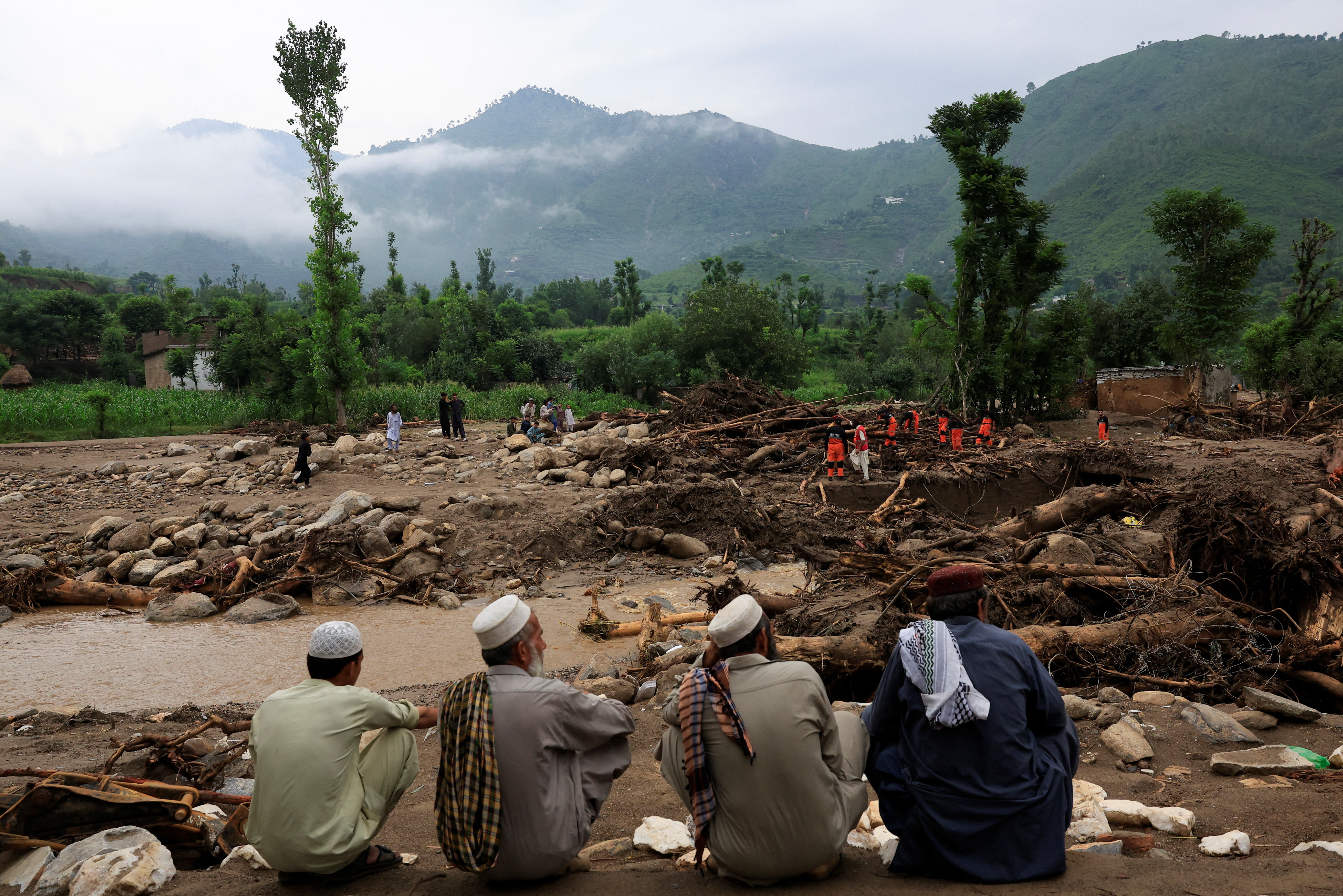 Residents sit as members of the Urban Search and Rescue team