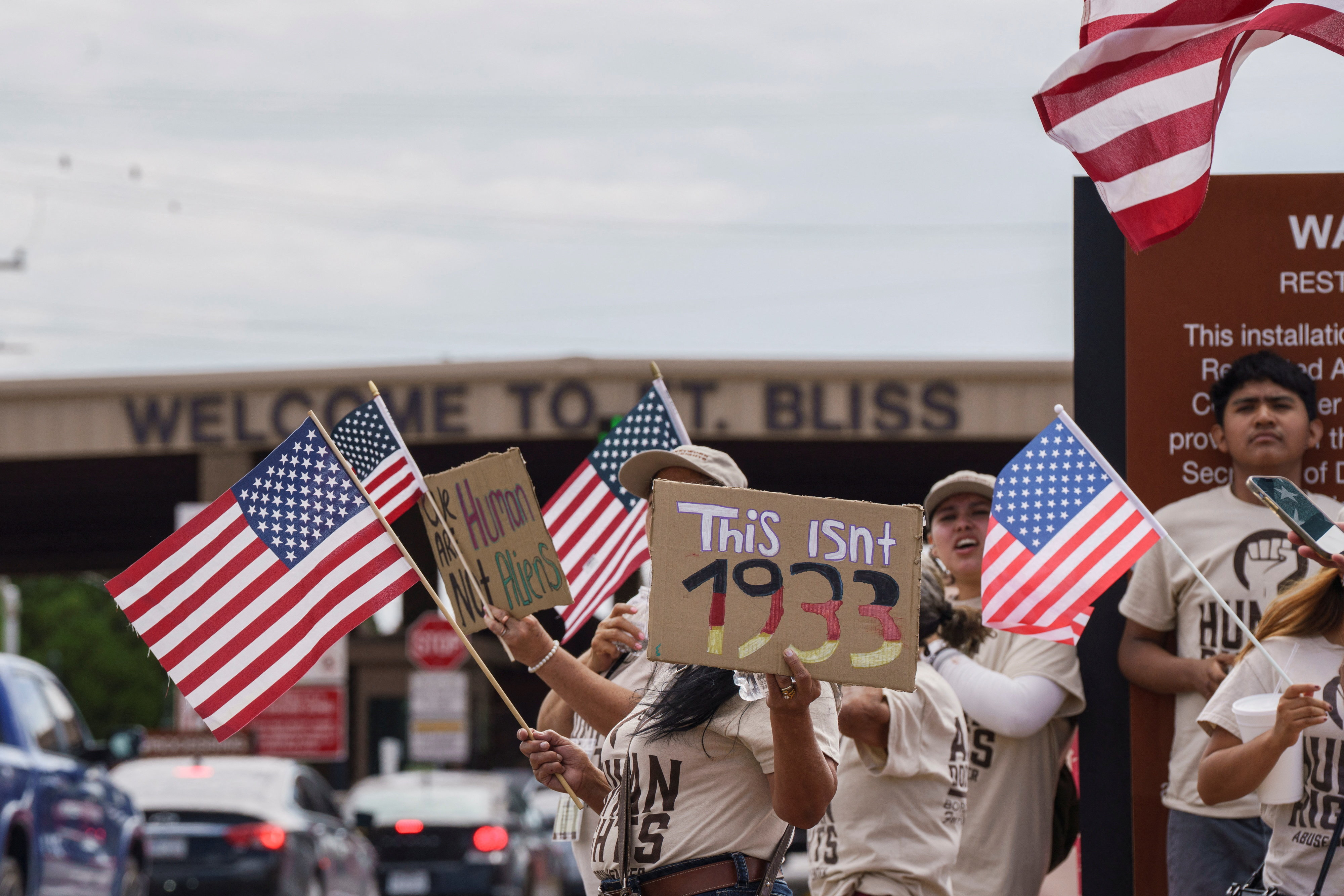 Protesters opposing mass deportations by ICE hold signs during a protest held in late August at the Cassidy Gate at Fort Bliss, the US Army base where a large new ICE detention facility is being built, in El Paso, Texas. [Paul Ratje/Reuters]