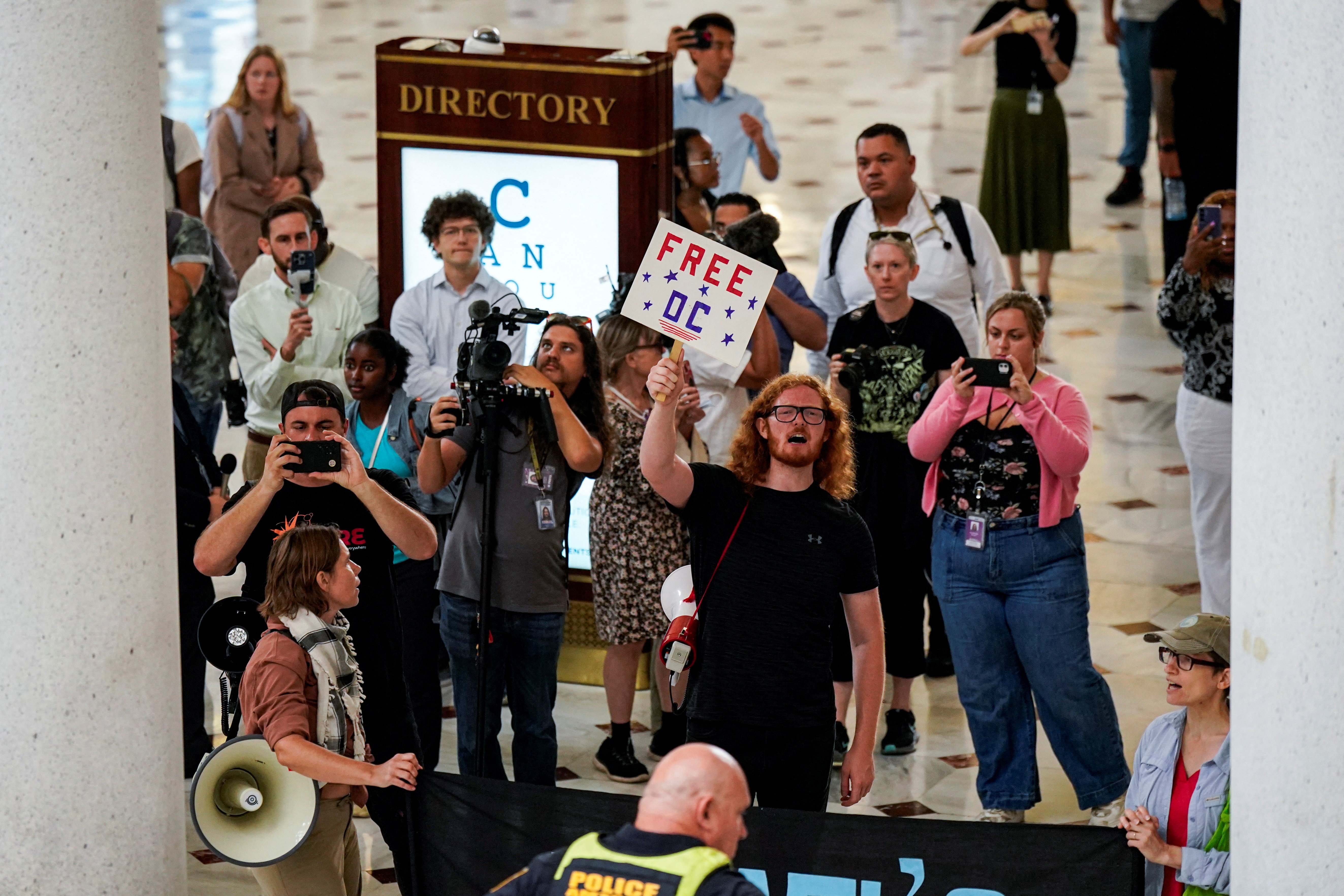 Demonstrators chant, as U.S. Vice President JD Vance, U.S. Defense Secretary Pete Hegseth and White House Deputy Chief of Staff Stephen Miller visit members of the National Guard, at Union Station in Washington, D.C., U.S., August 20, 2025. REUTERS/Al Drago/Pool