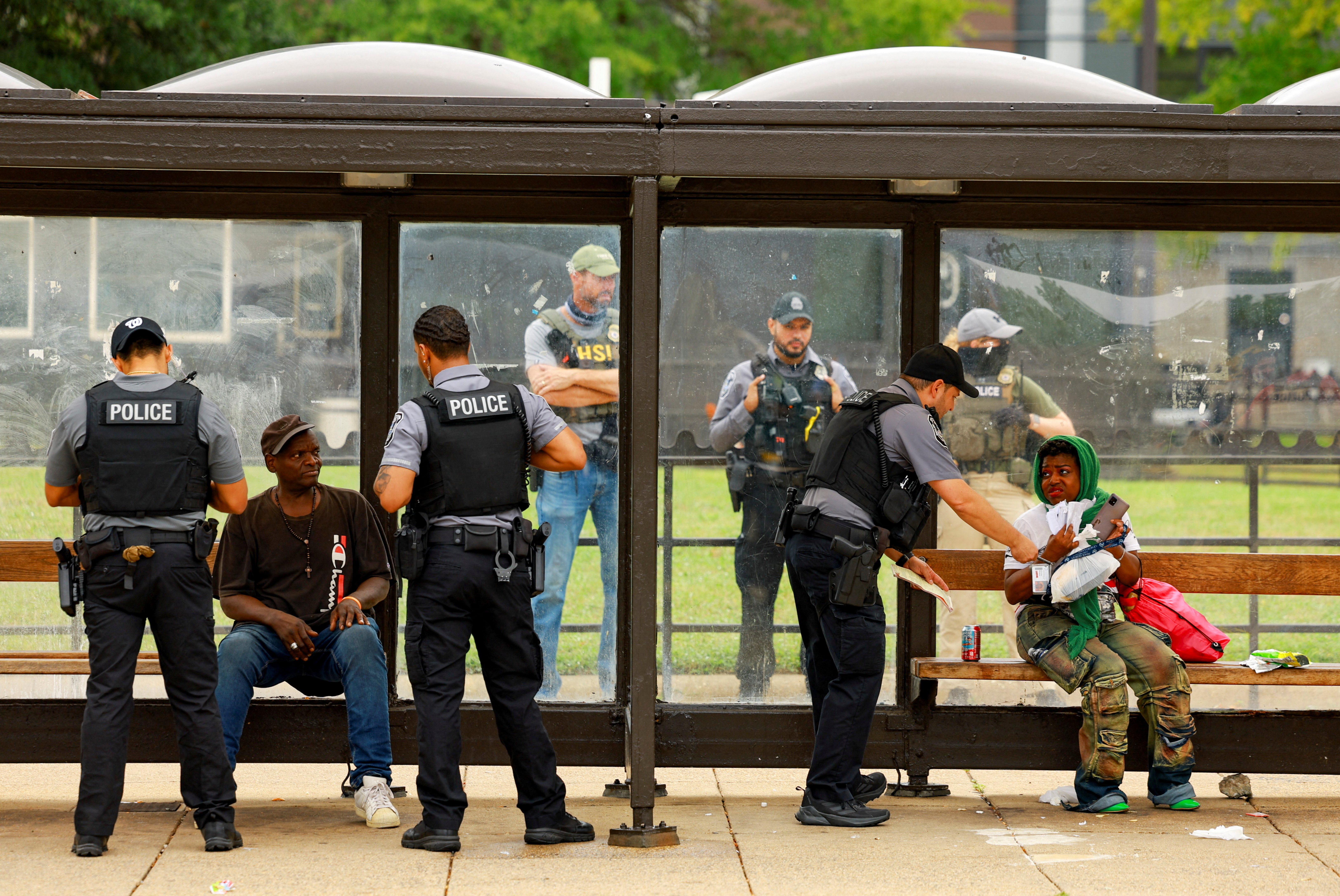 Police officers check individuals at the Anacostia bus station in Washington, D.C., U.S., August 20, 2025. REUTERS/Jose Luis Gonzalez TPX IMAGES OF THE DAY