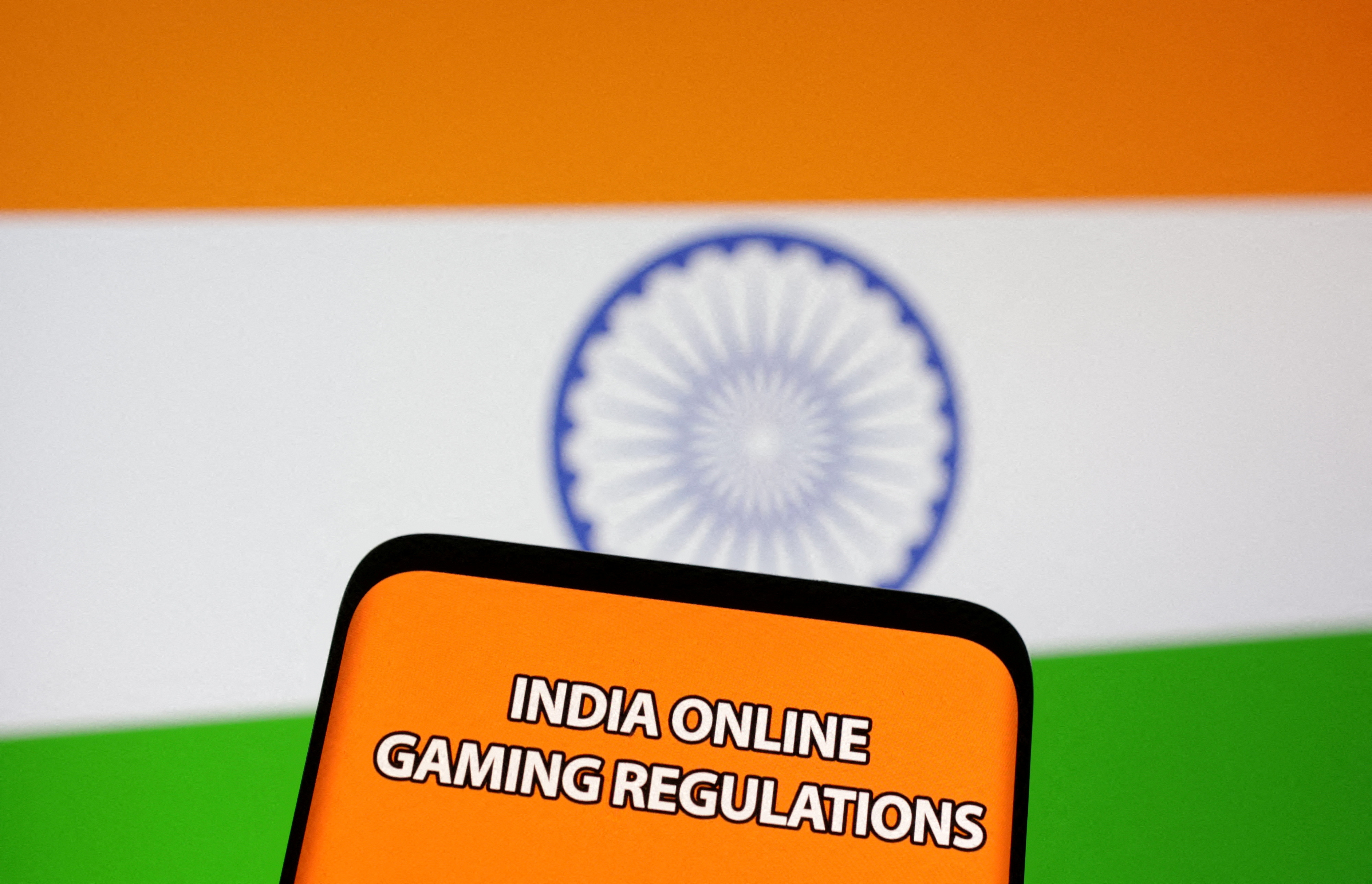 The words "India online gaming regulations" are displayed in front of an Indian flag in this Illustration