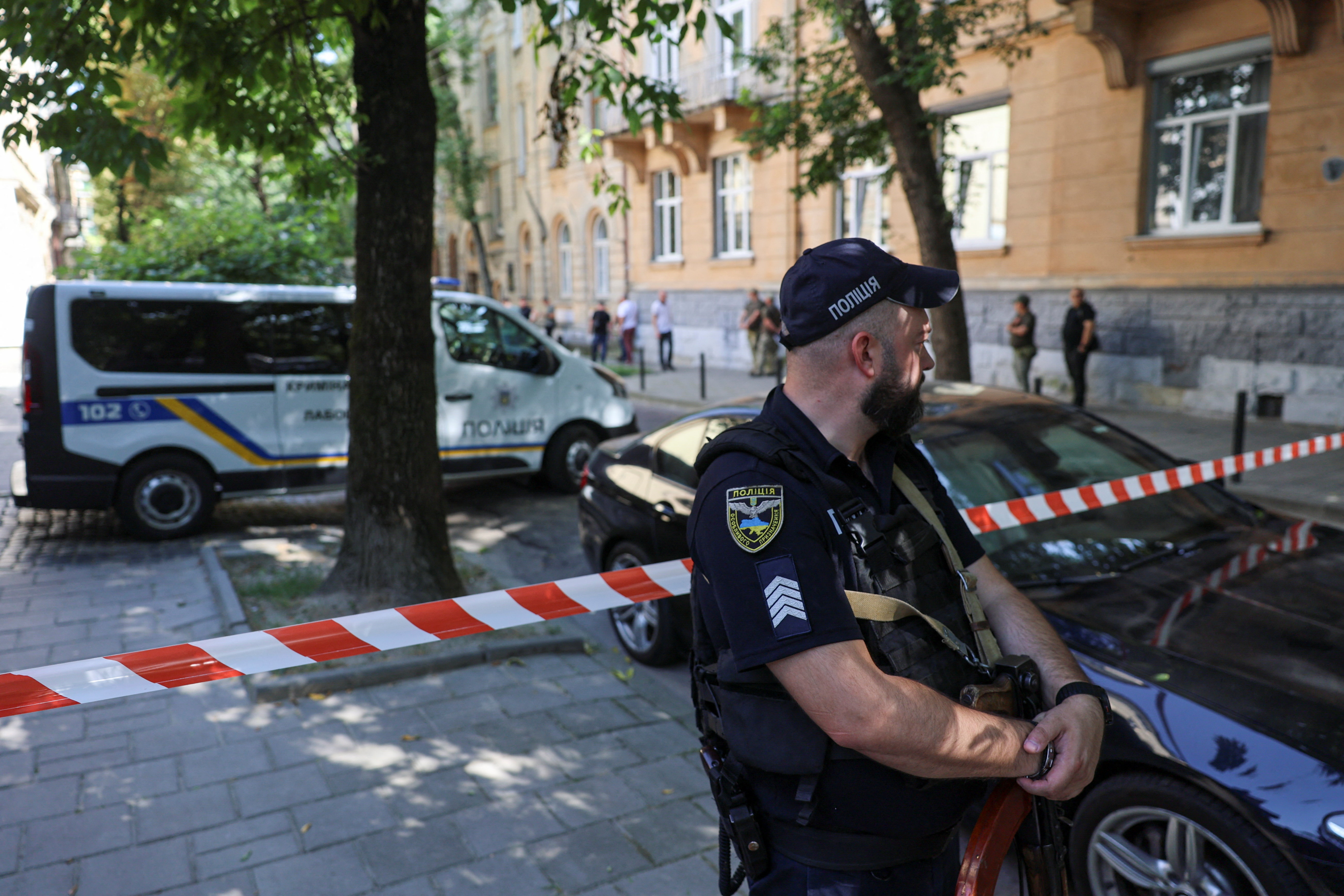 A police officer stands at the scene of Andrii Sybiha's fatal shooting