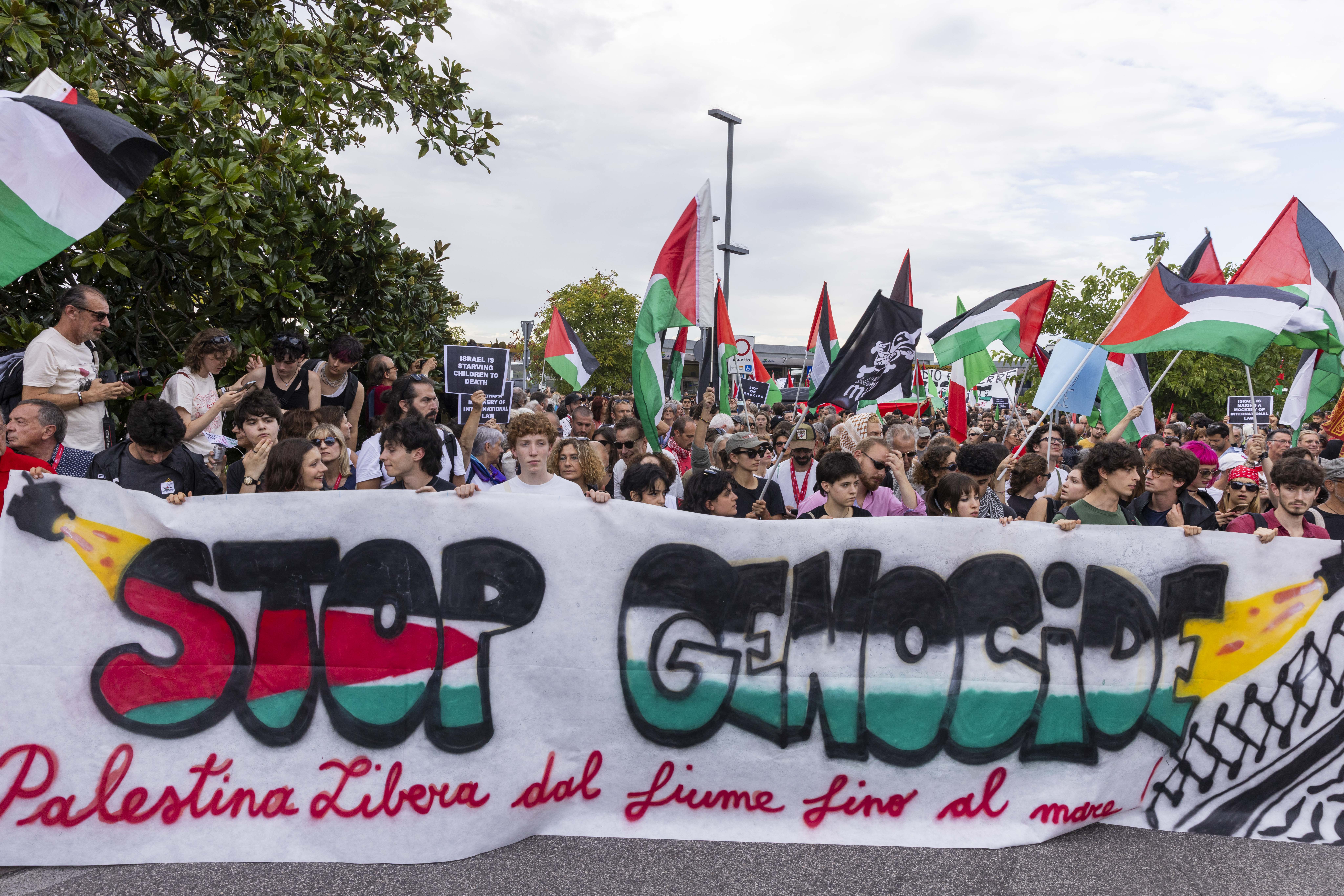 Demonstrators wave Palestinian flags and holding banners during a protest against genocide in Gaza in Venice, Italy