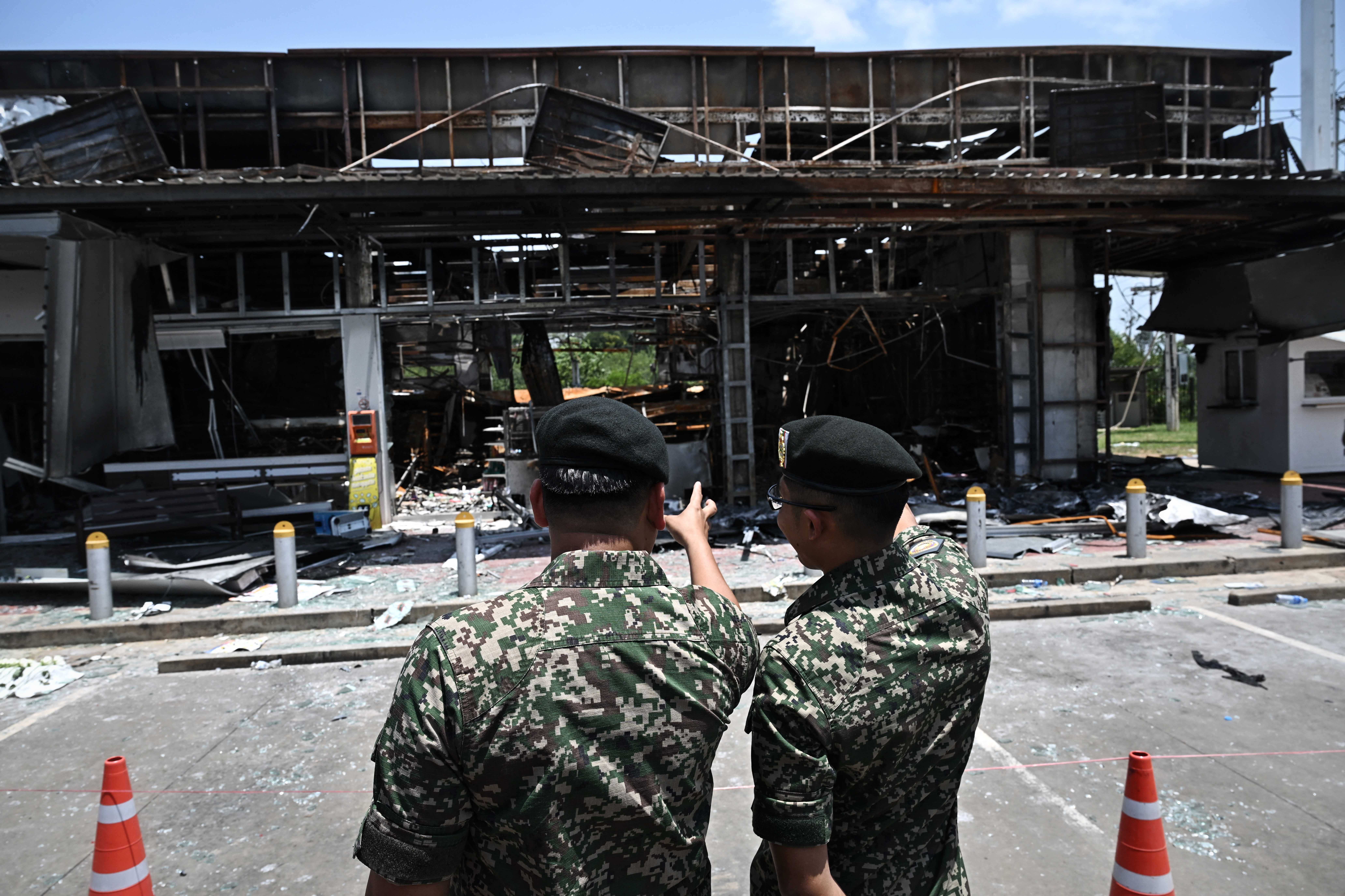 Military attaches and diplomats from 23 countries visit the 7-11 convenience store at a Thai gas station that was hit by Cambodian artillery and resulted in eight deaths, during a media tour organised by the Royal Thai Army and Ministry of Foreign Affairs to observe damage due to clashes between Thailand and Cambodia, in Kantharalak town in the Thai border province of Sisaket on August 1, 2025. The two countries agreed on July 28 a ceasefire following five days of clashes that killed at least 43 people on both sides -- the latest eruption of a long-standing dispute over contested border temples. (Photo by Lillian SUWANRUMPHA / AFP)