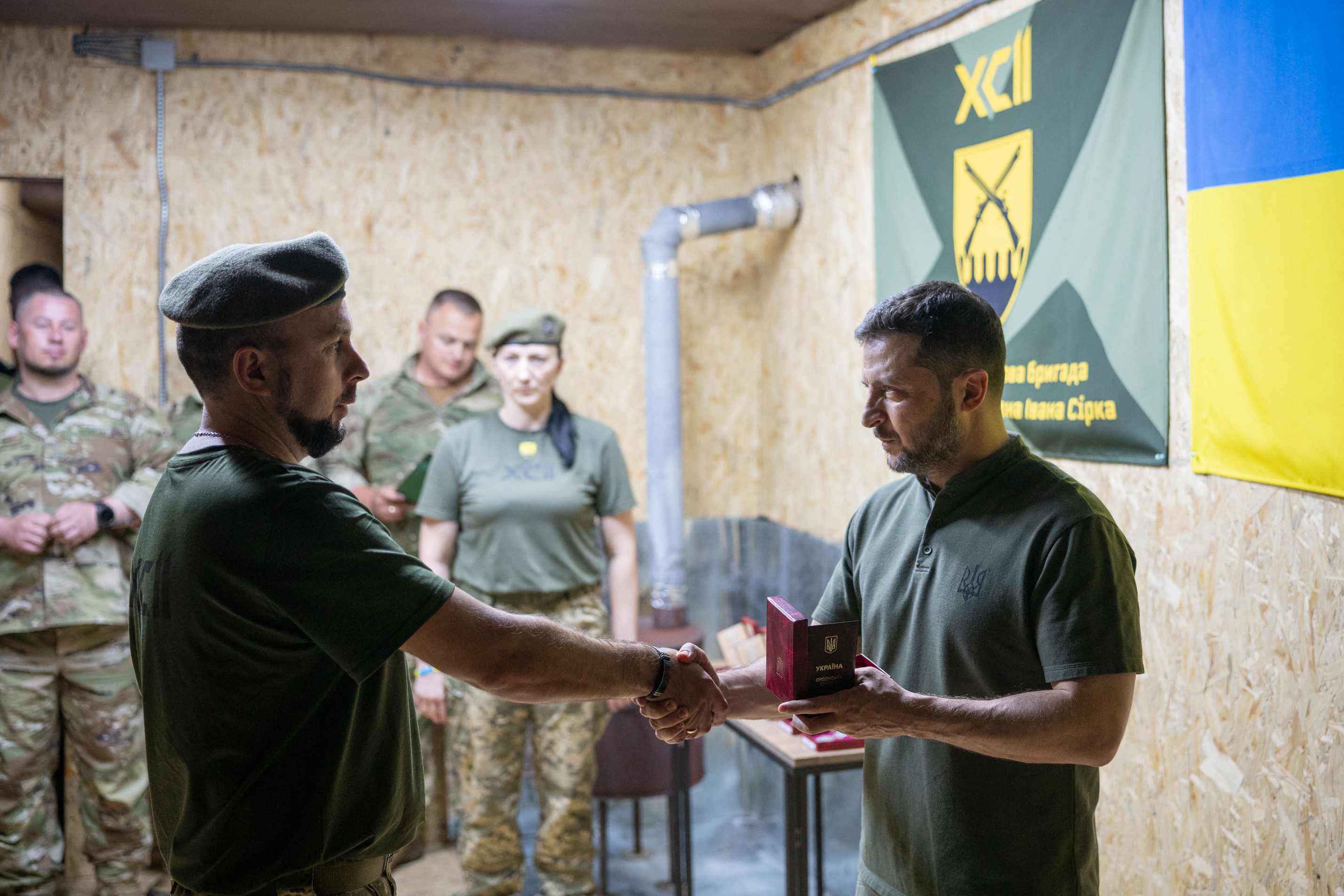 Ukraine's President Volodymyr Zelensky (R) presents a medal to a Ukrainian serviceman