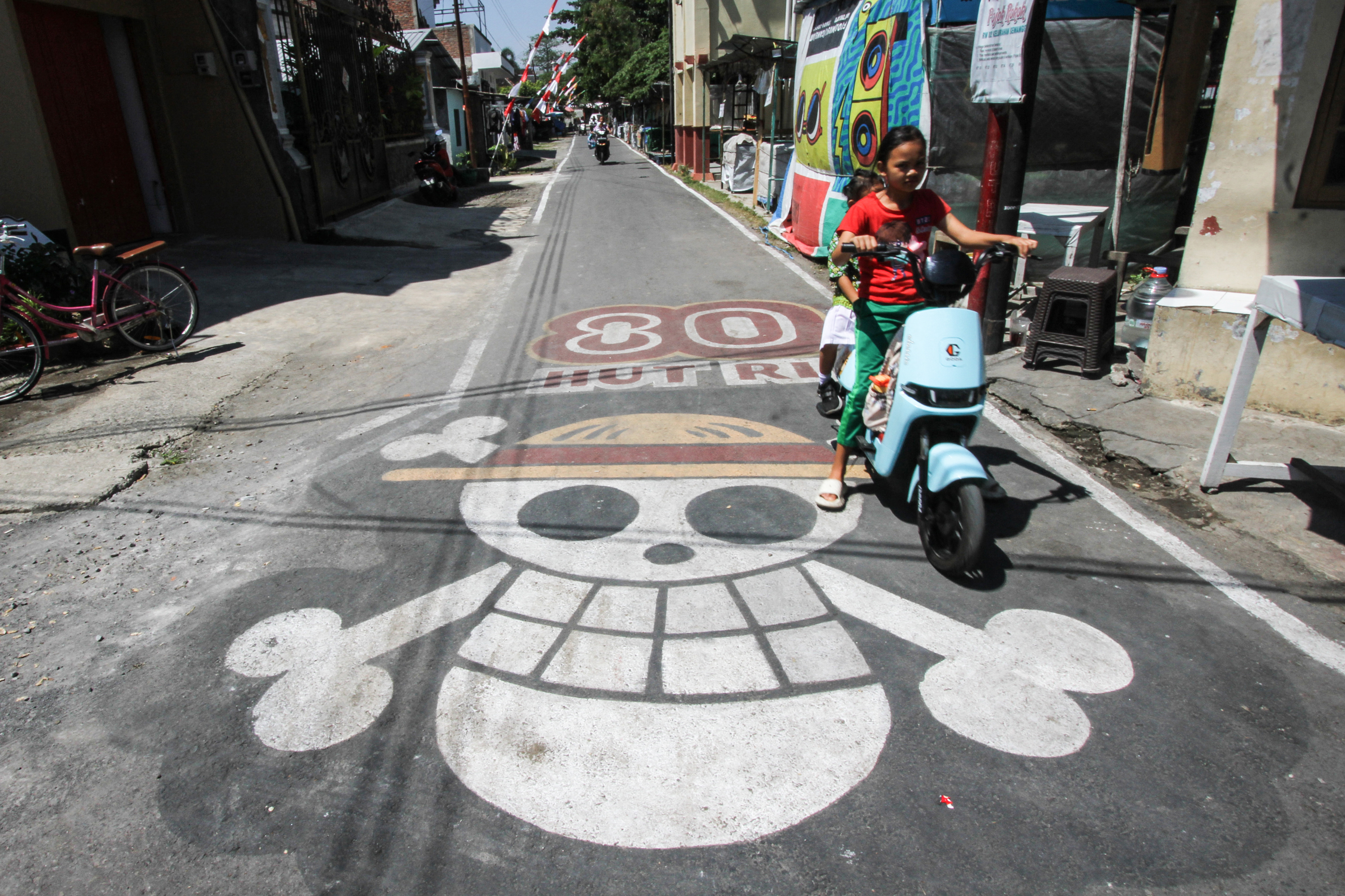 A graffiti of the pirate flag from Japanese anime One Piece, adopted by some Indonesians as a symbol of frustration with their government, is seen on a street in Sukoharjo, Central Java, on August 6, 2025, ahead of the countrys 80th Independence Day. As Indonesia's independence day approaches red and white flags will be flown across the country, but a viral anime pirate banner has drawn government threats against flying the swashbuckling ensign. A Jolly Roger skull and bone symbol topped with a straw hat from Japan's anime series 'One Piece' has caused concern among officials in Jakarta that it is being used to criticise President Prabowo Subianto's policies. (Photo by DIKA / AFP) / TO GO WITH 'INDONESIA-POLITICS-PROTEST-ANIME, FOCUS' BY DESSY SAGITA & JACK MOORE
