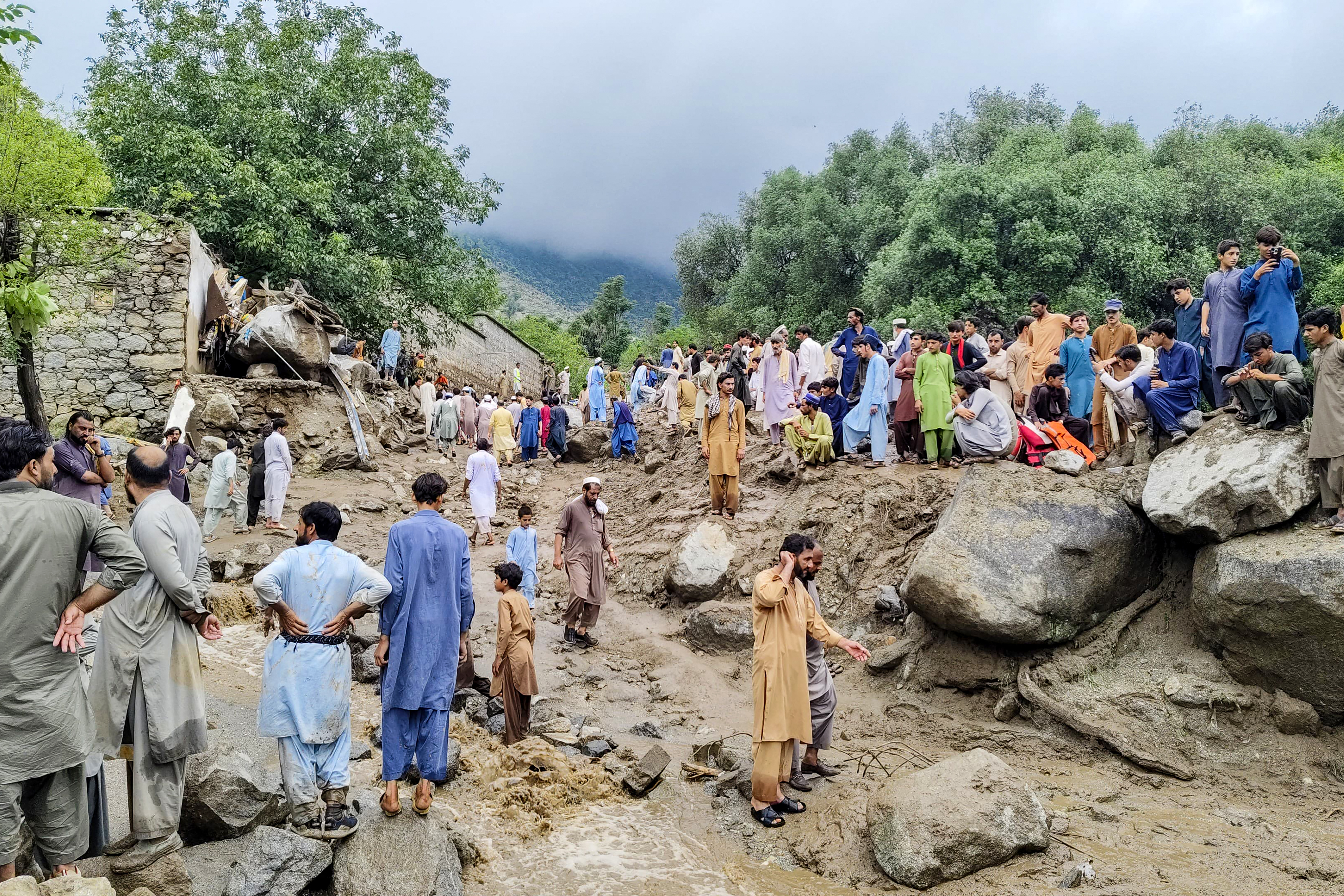 People gathered at the site of a flashflood in Salarzai Tehsil of Pakistan's Bajaur district