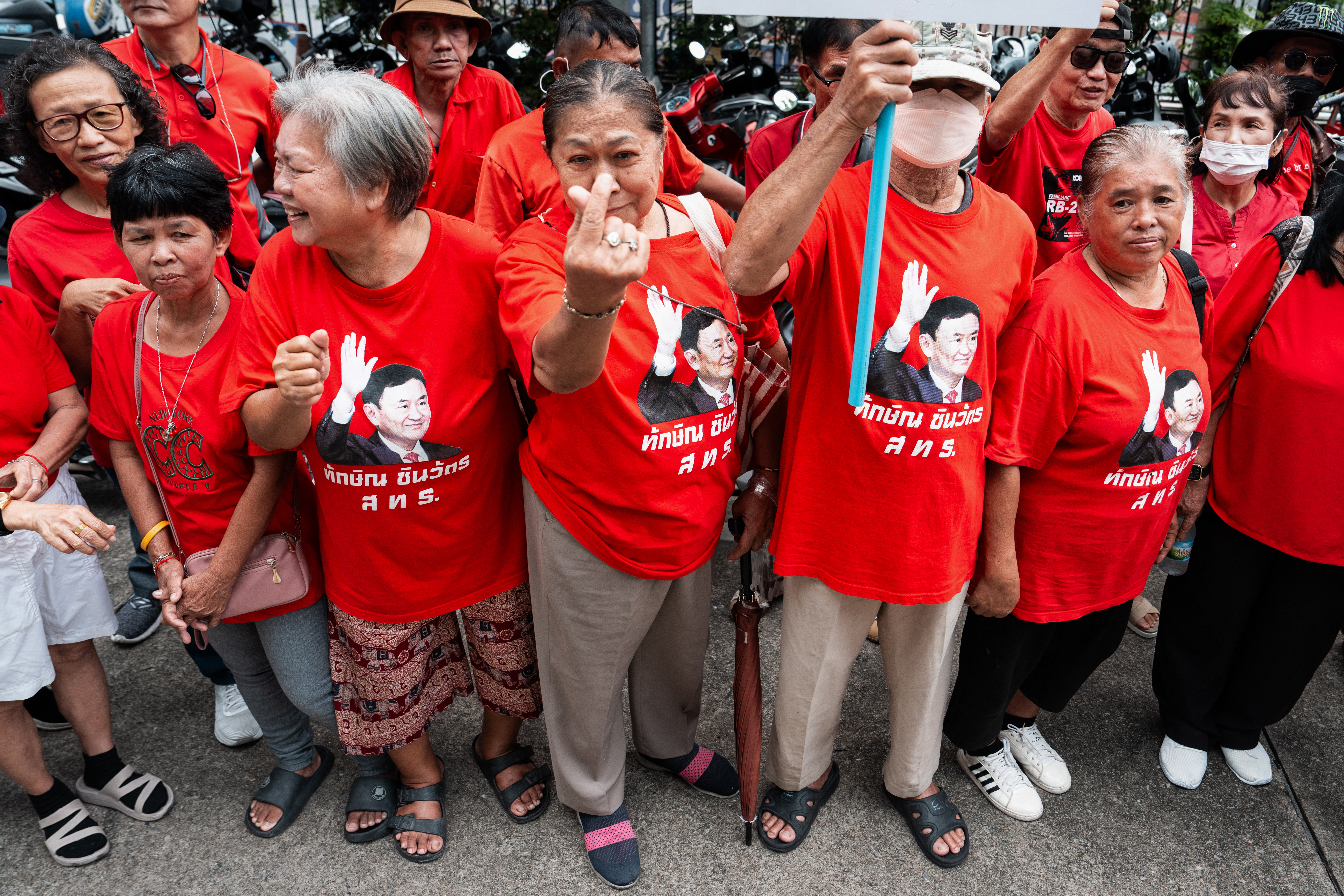 Supporters of Thailand's former prime minister Thaksin Shinawatra gather in front of the Criminal Court in Bangkok on August 22, 2025. Thaksin said he was acquitted on August 22 of royal defamation charges, relieving him of a threat to his faltering dynasty which has dominated politics for two decades. (Photo by Chanakarn Laosarakham / AFP)