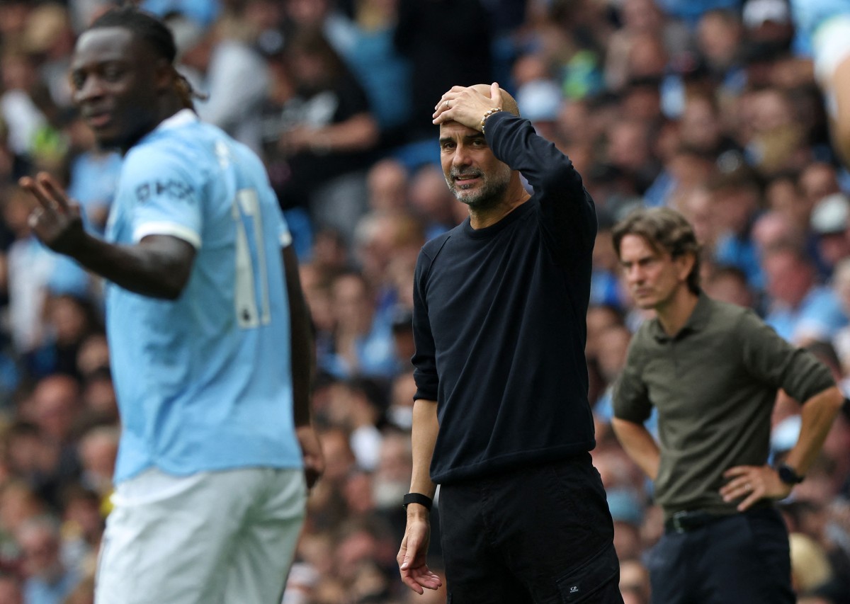 Manchester City's Spanish manager Pep Guardiola (C) and Tottenham Hotspur's Danish head coach Thomas Frank (R) react during the English Premier League football match
