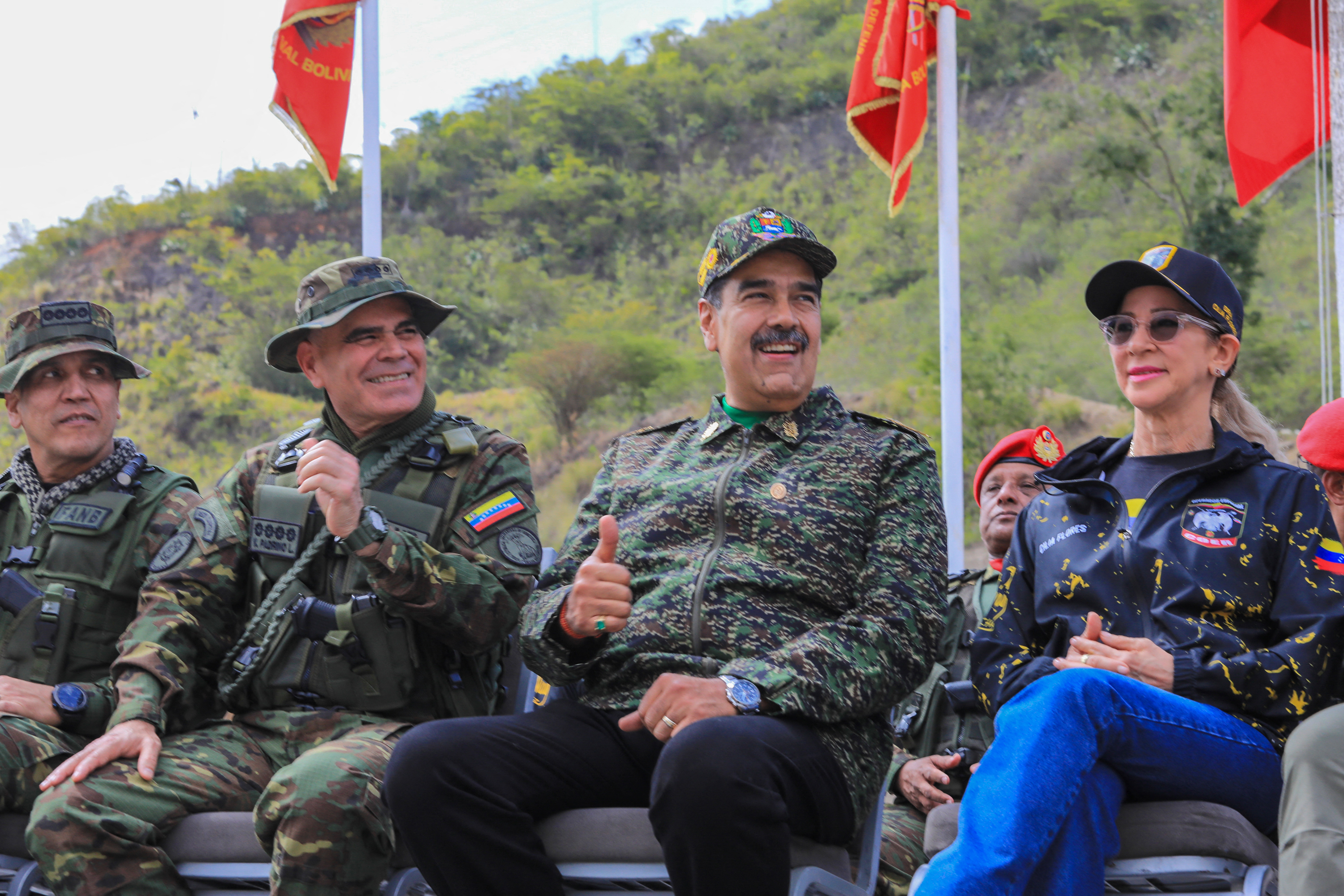 This handout picture released by the Venezuelan Presidency on August 28, 2025, shows Venezuela's President Nicolas Maduro (C-R) giving a thumbs up next to Defense Minister Vladimir Padrino Lopez (C-L) and First Lady Cilia Flores (R) as they watch military exercises at a training camp in Caracas. Venezuela's President Nicolas Maduro said that "there is no way" a foreign force could invade Venezuela on August 28, 2025, amid military operations announced by the United States in the Caribbean, which the leftist leader describes as a "threat" to his country. (Photo by ZURIMAR CAMPOS / Venezuelan Presidency / AFP) / RESTRICTED TO EDITORIAL USE - MANDATORY CREDIT "AFP PHOTO / VENEZUELAN PRESIDENCY / ZURIMAR CAMPOS" - HANDOUT - NO MARKETING NO ADVERTISING CAMPAIGNS - DISTRIBUTED AS A SERVICE TO CLIENTS - AFP CANNOT INDEPENDENTLY VERIFY THE AUTHENTICITY OR LOCATION, DATE, AND CONTENT OF THESE IMAGES. /