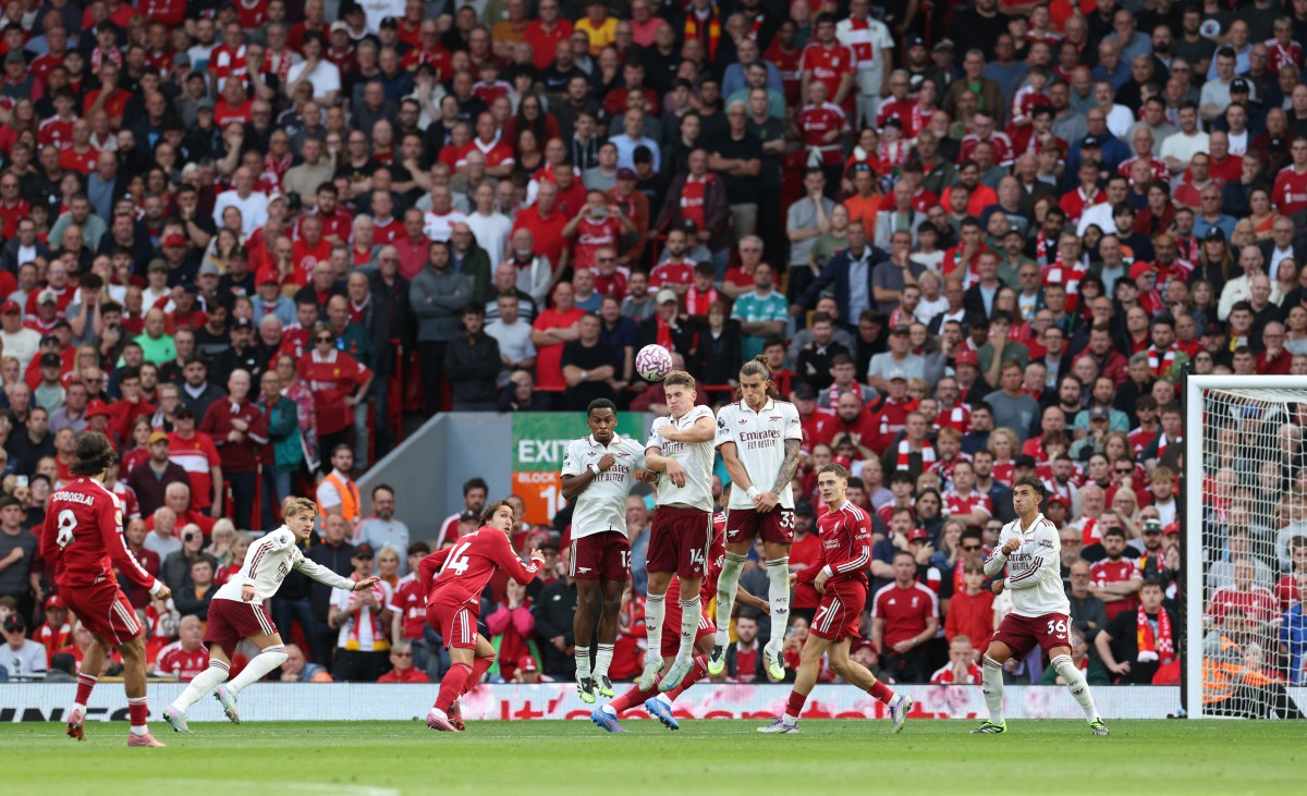 Liverpool's Hungarian midfielder #08 Dominik Szoboszlai (L) strikes the ball over the wall from a free kick to score the opening goal during the English Premier League football match between Liverpool and Arsenal