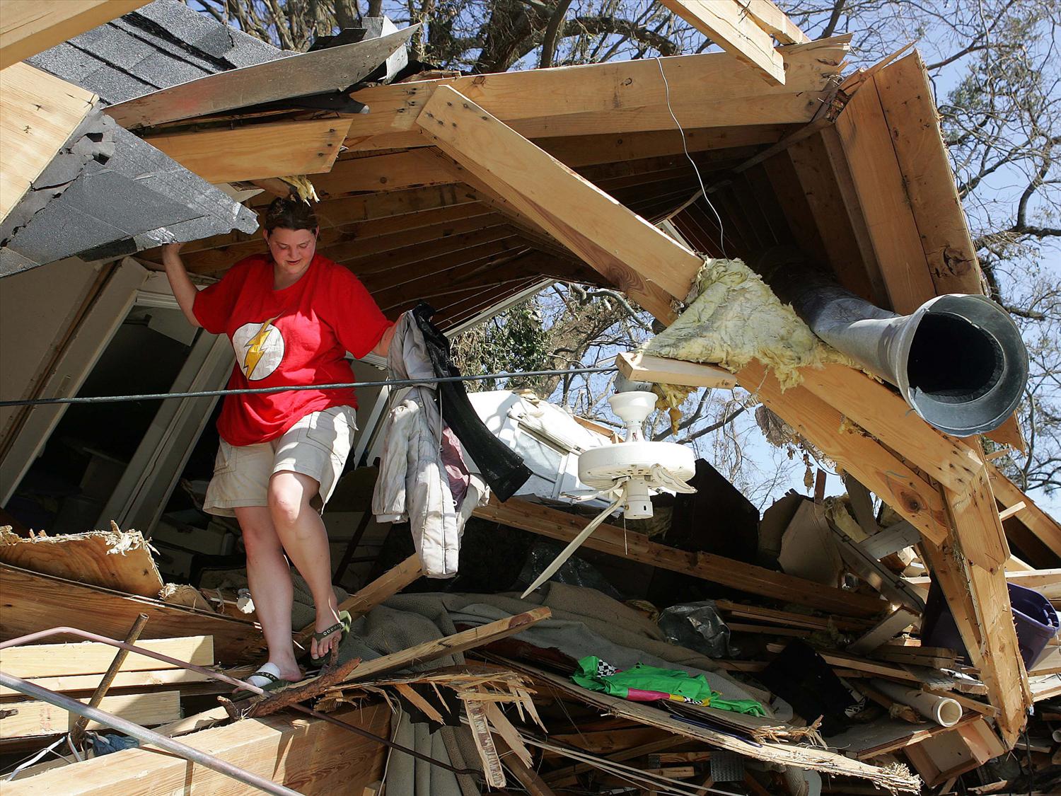 A person walks in the rubble of a demolished home