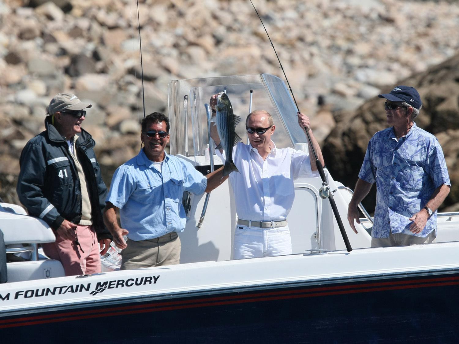 Putin holding up a fish he caught in Maine, while visiting US President George W Bush and his family on July 2, 2007 [FILE: AP Photo]