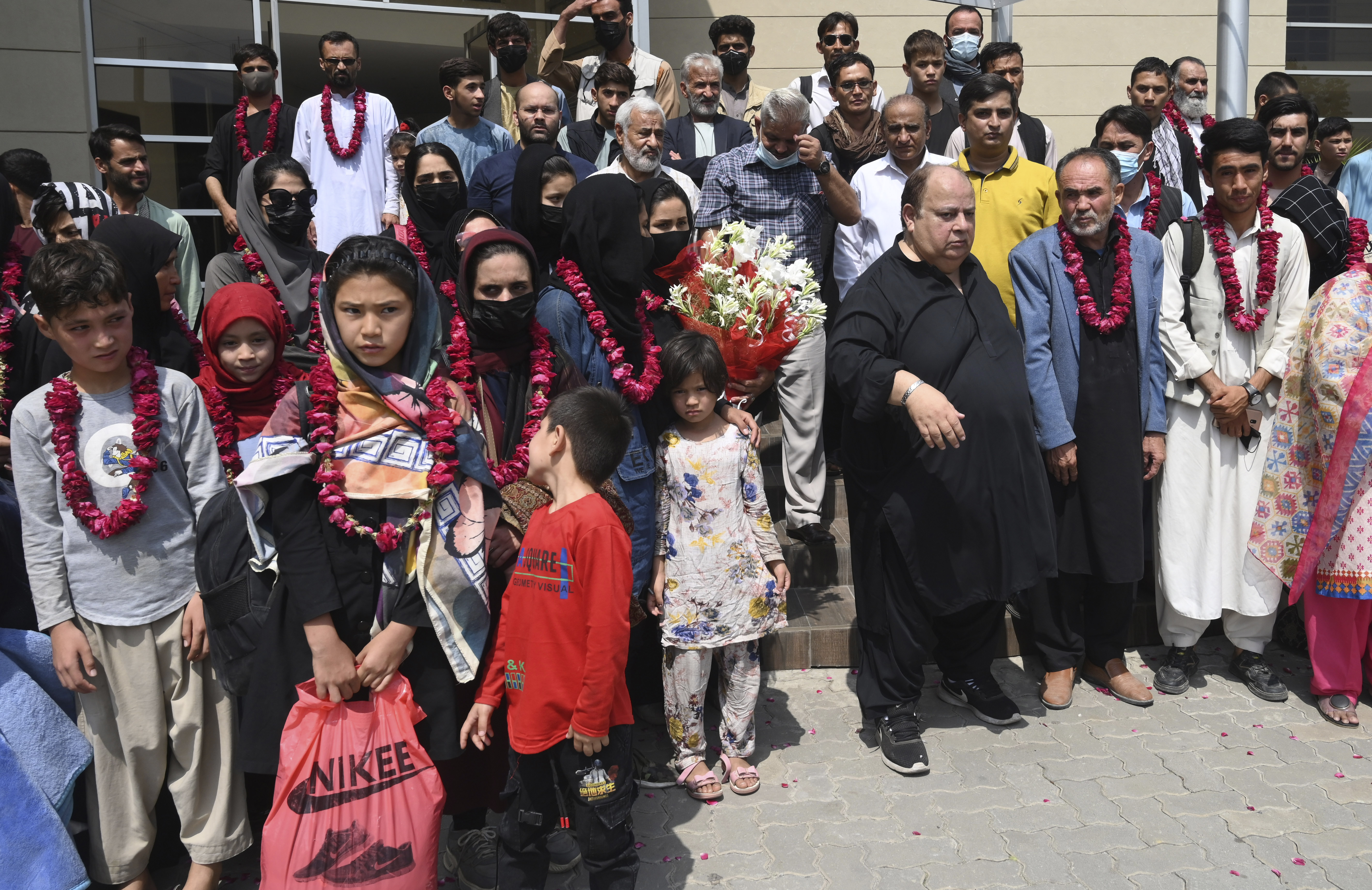 Members of Afghanistan's women soccer team and their families pose for a photograph after they were greeted by officials of the Pakistan Football Federation, in Lahore, Pakistan, Wednesday, Sept. 15, 2021