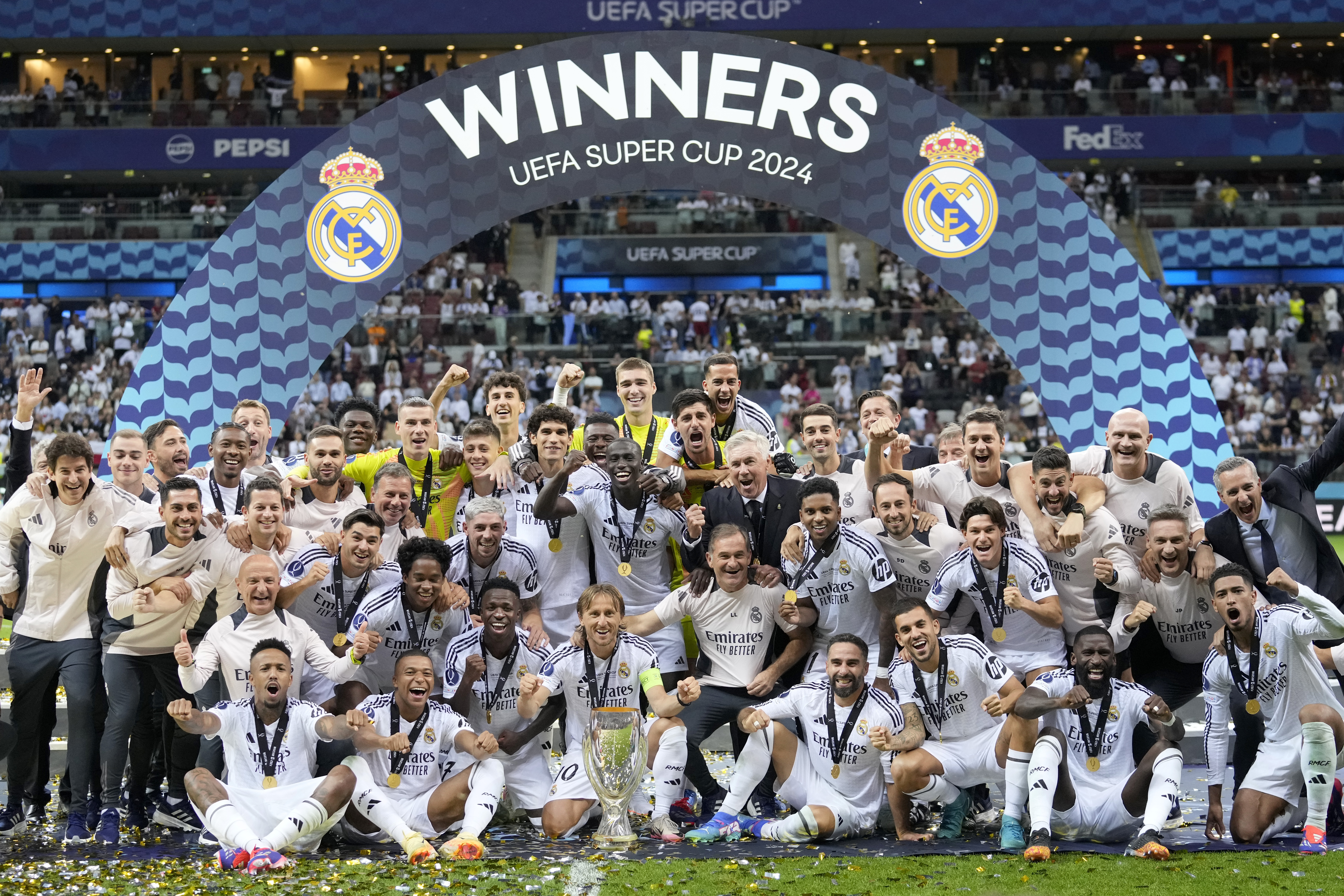 Real Madrid players and staff pose with the trophy after winning the UEFA Super Cup Final