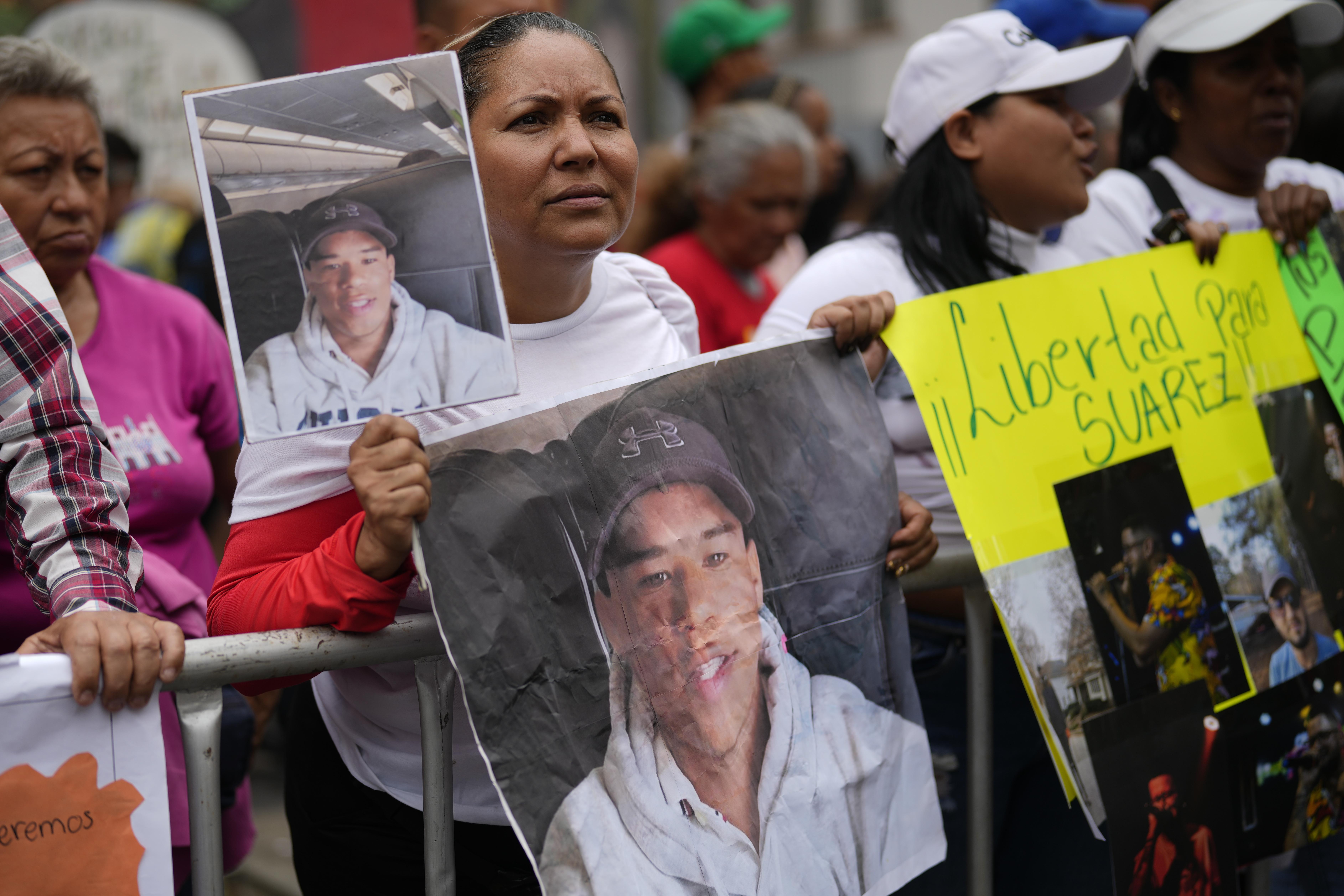 Protesters hold up photos of Venezuelans deported to El Salvador from US