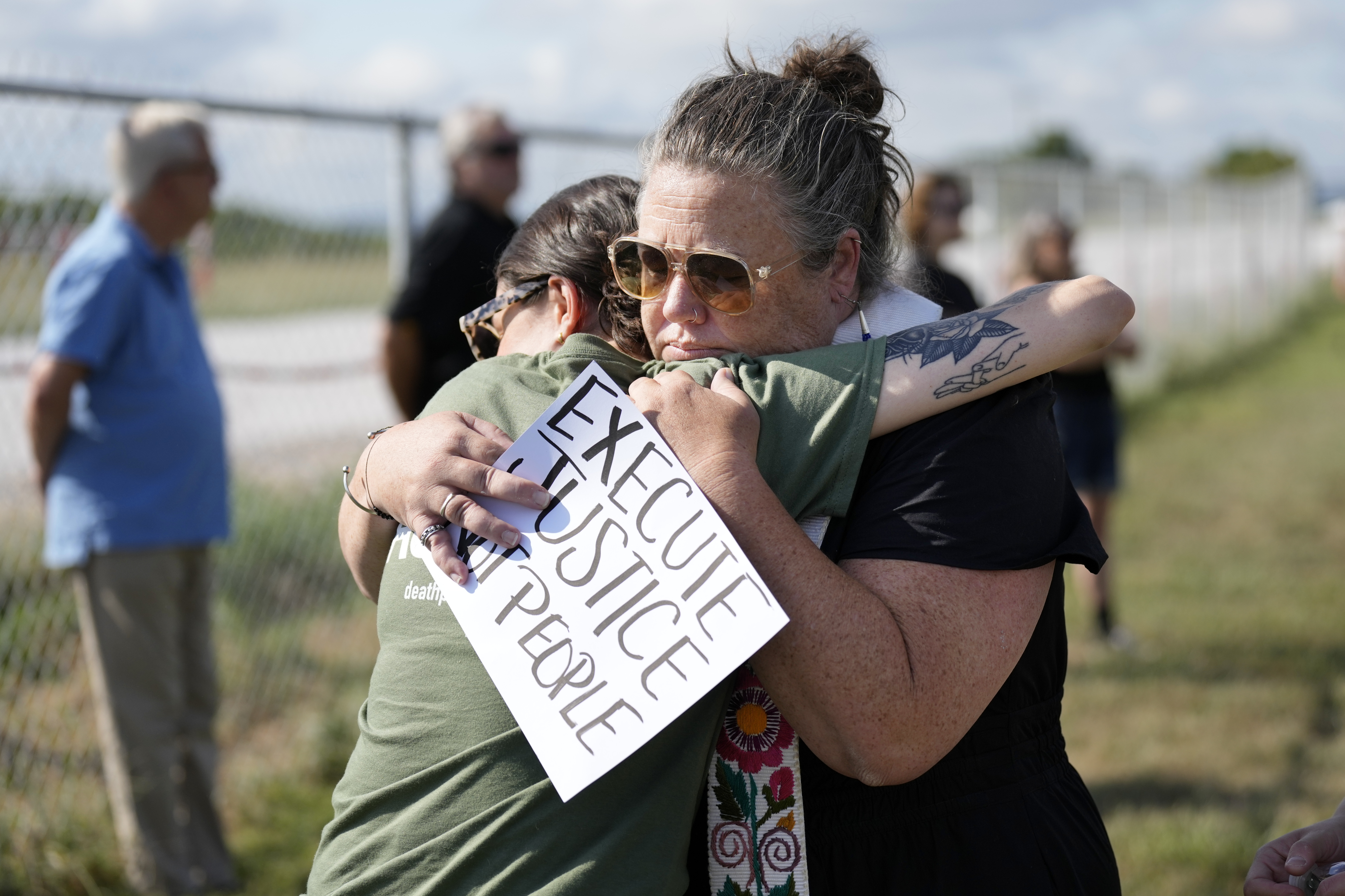 Anti-death penalty demonstrators hug outside a prison in Nashville.