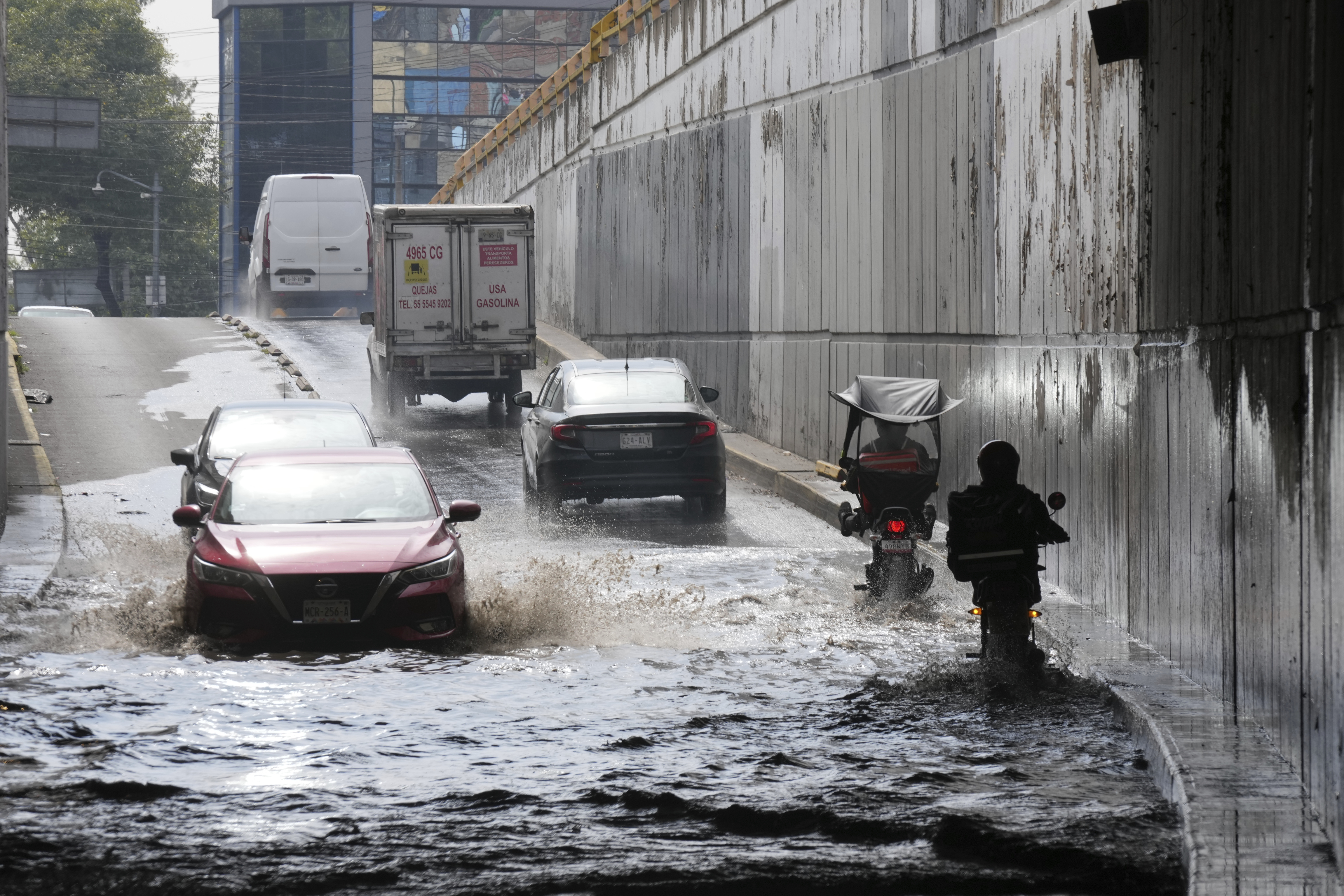 Drivers cross a flooded street just outside the Benito Juárez International Airport in Mexico City on August 12, 2025.
