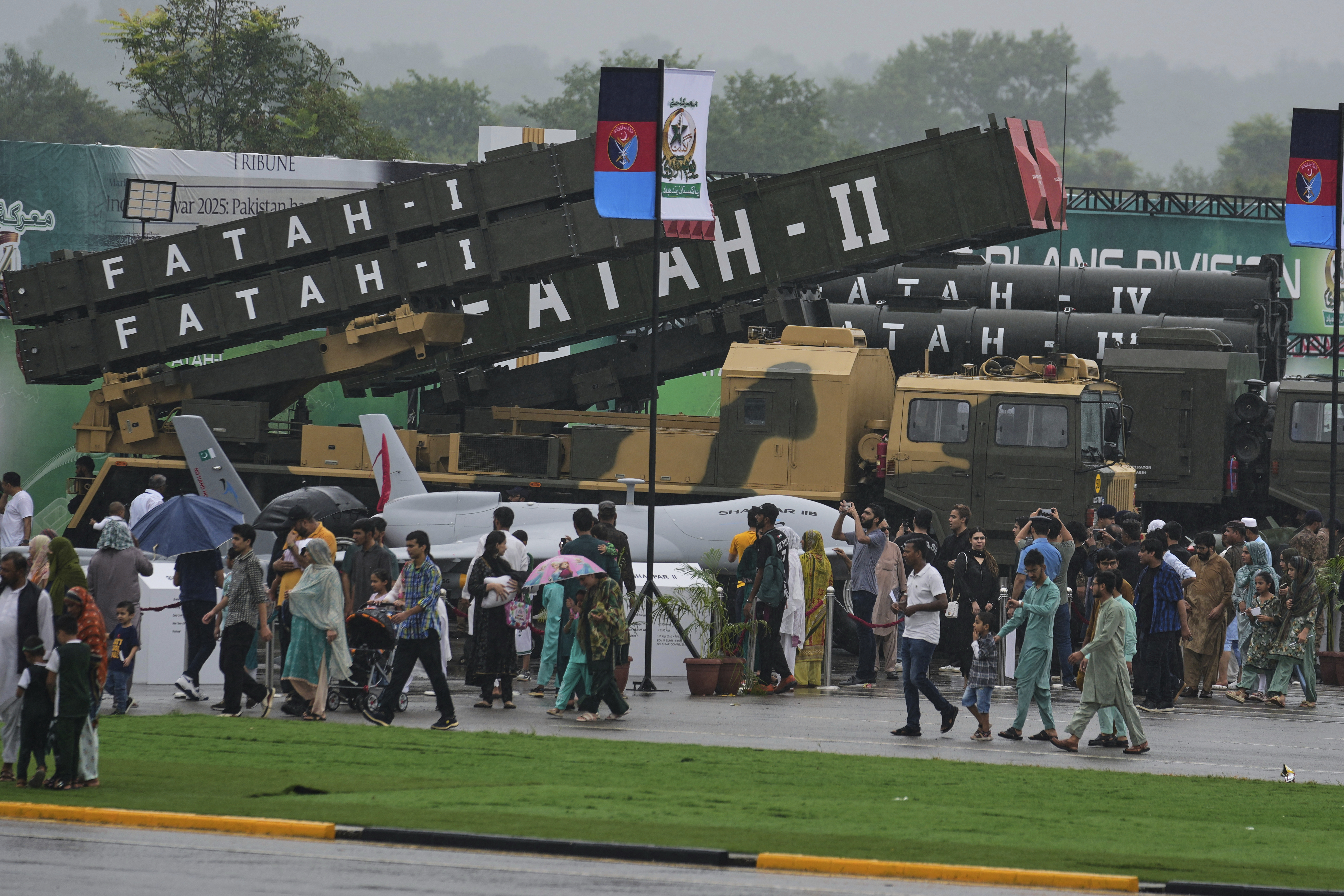 People look at ballistic missiles, unmanned drones and other items during a defence exhibition.