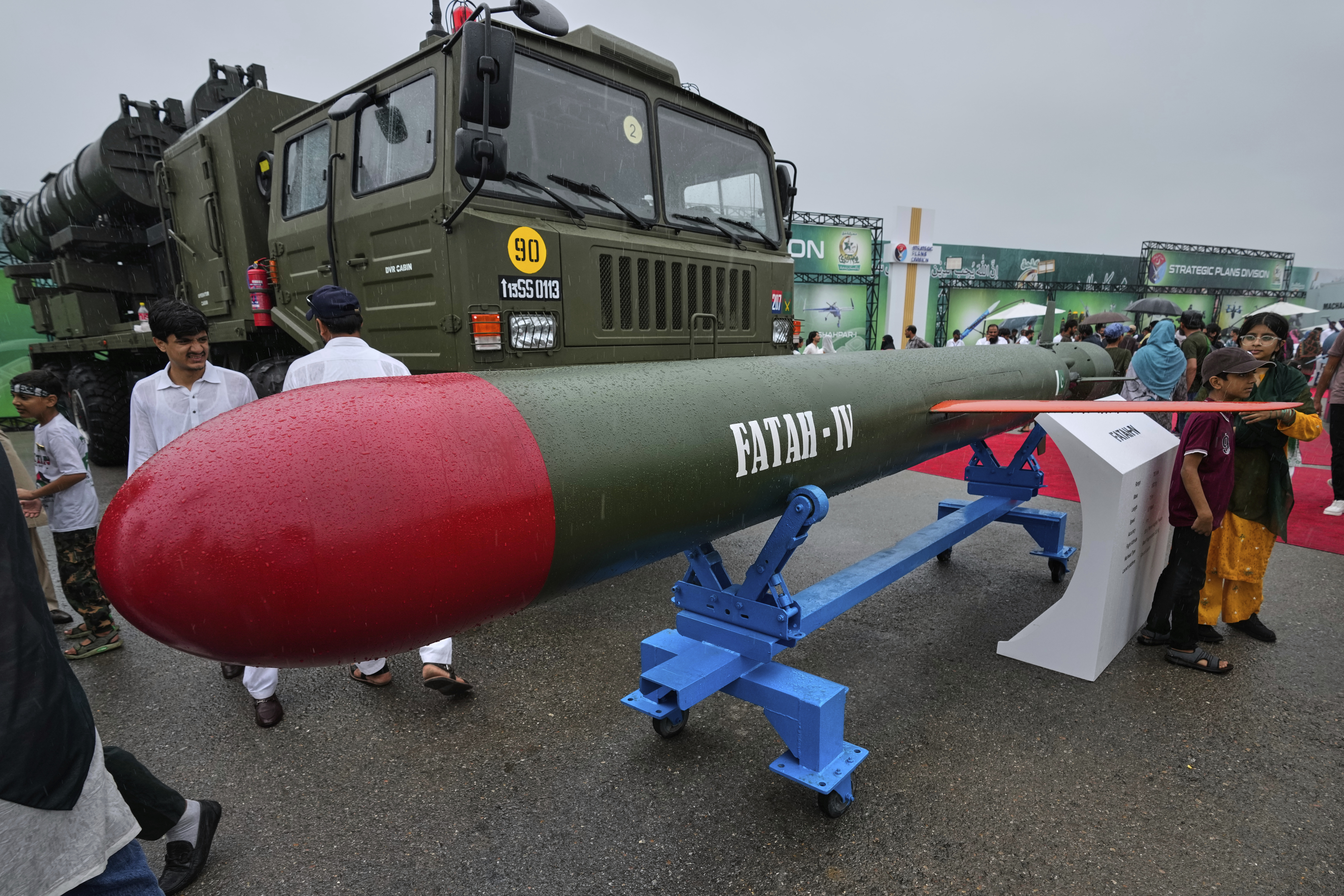 Children pose for photograph with Hatf-IV, a land-based short-ranged ballistic missile, with launcher during a defense exhibition held as part of Pakistan's Independence Day celebrations, in Islamabad, Pakistan, Thursday, Aug. 14, 2025. (AP Photo/Anjum Naveed)