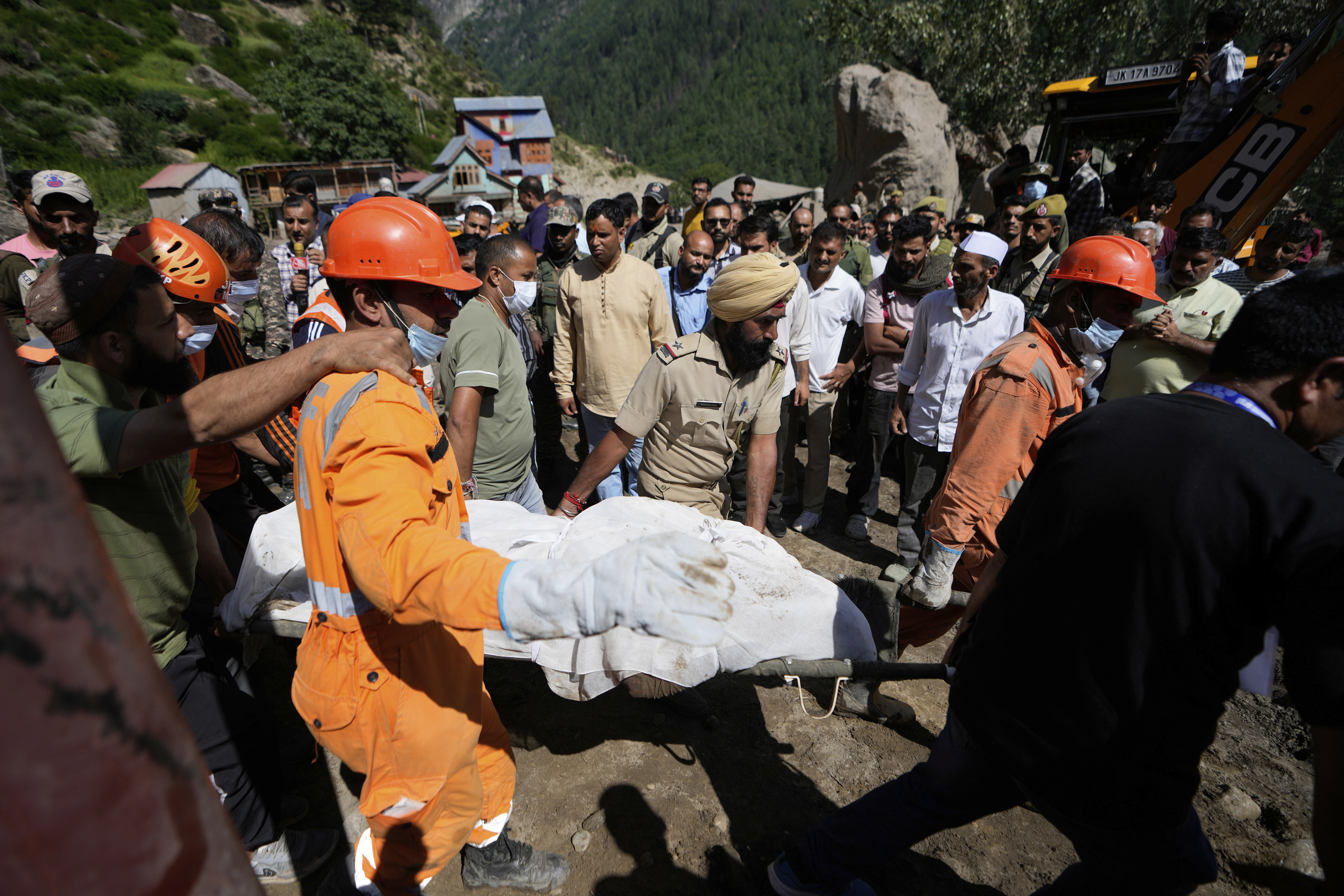 India's National Disaster Response Force (NDRF) and police personnel carry a dead body on a stretcher during rescue operations after Thursday's flash floods in Chositi village, Kishtwar district, Indian-controlled Kashmir, Saturday, Aug. 16, 2025. (AP Photo/Channi Anand)