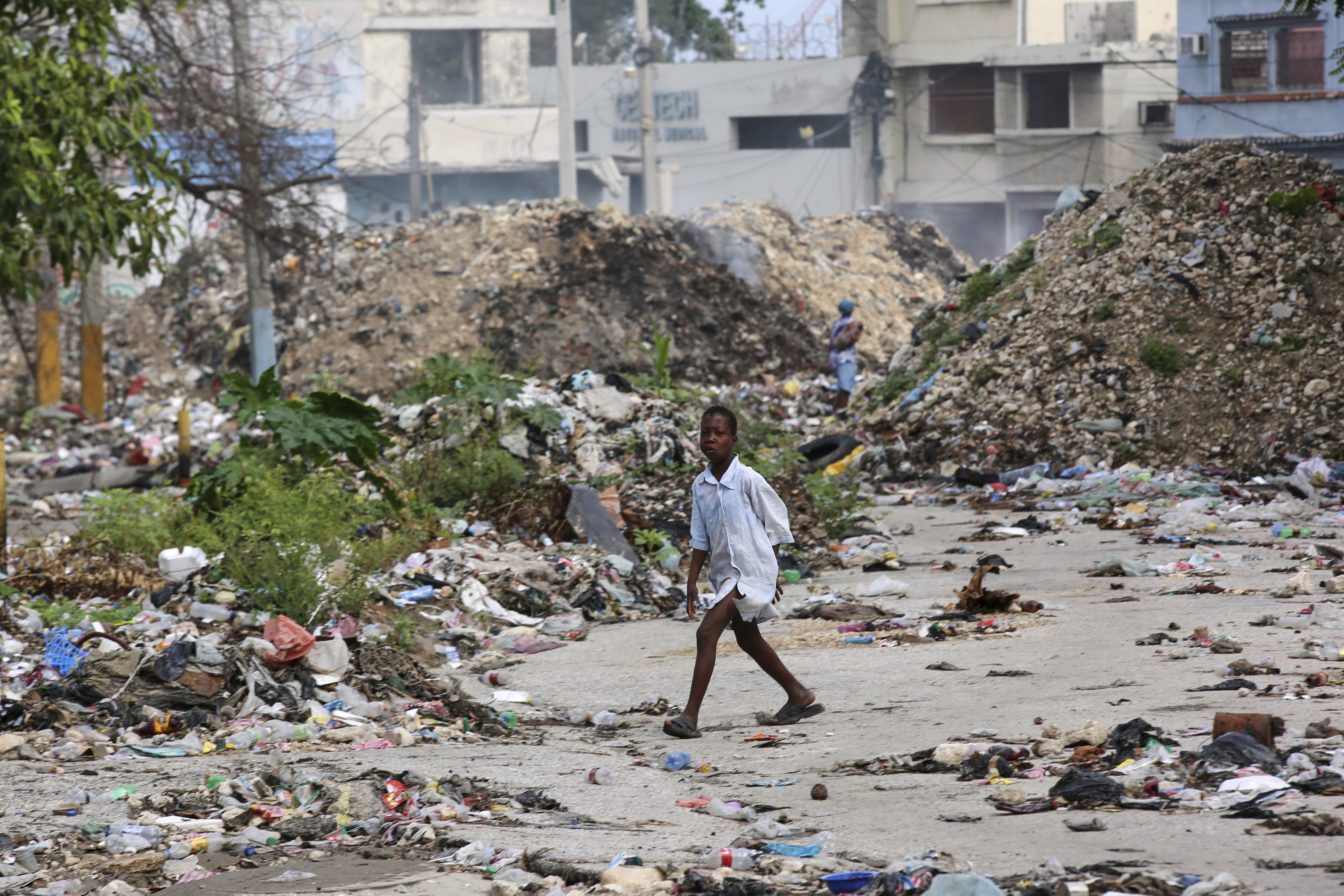 A child walks past mounds of garbage in Port-au-Prince