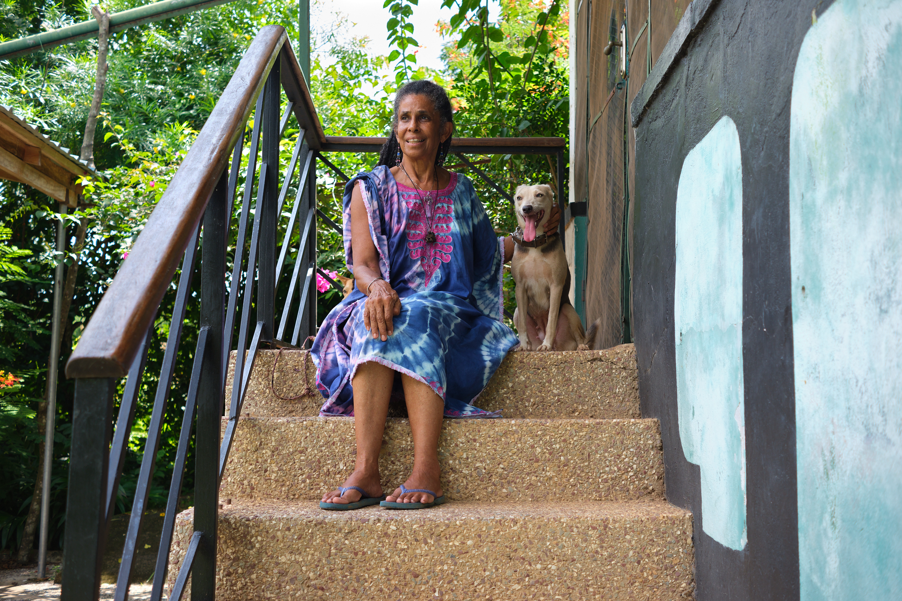 Harriet Kaufman sitting with her dogs in front of the Business centre entrance [Alfred Quartey/Al Jazeera]