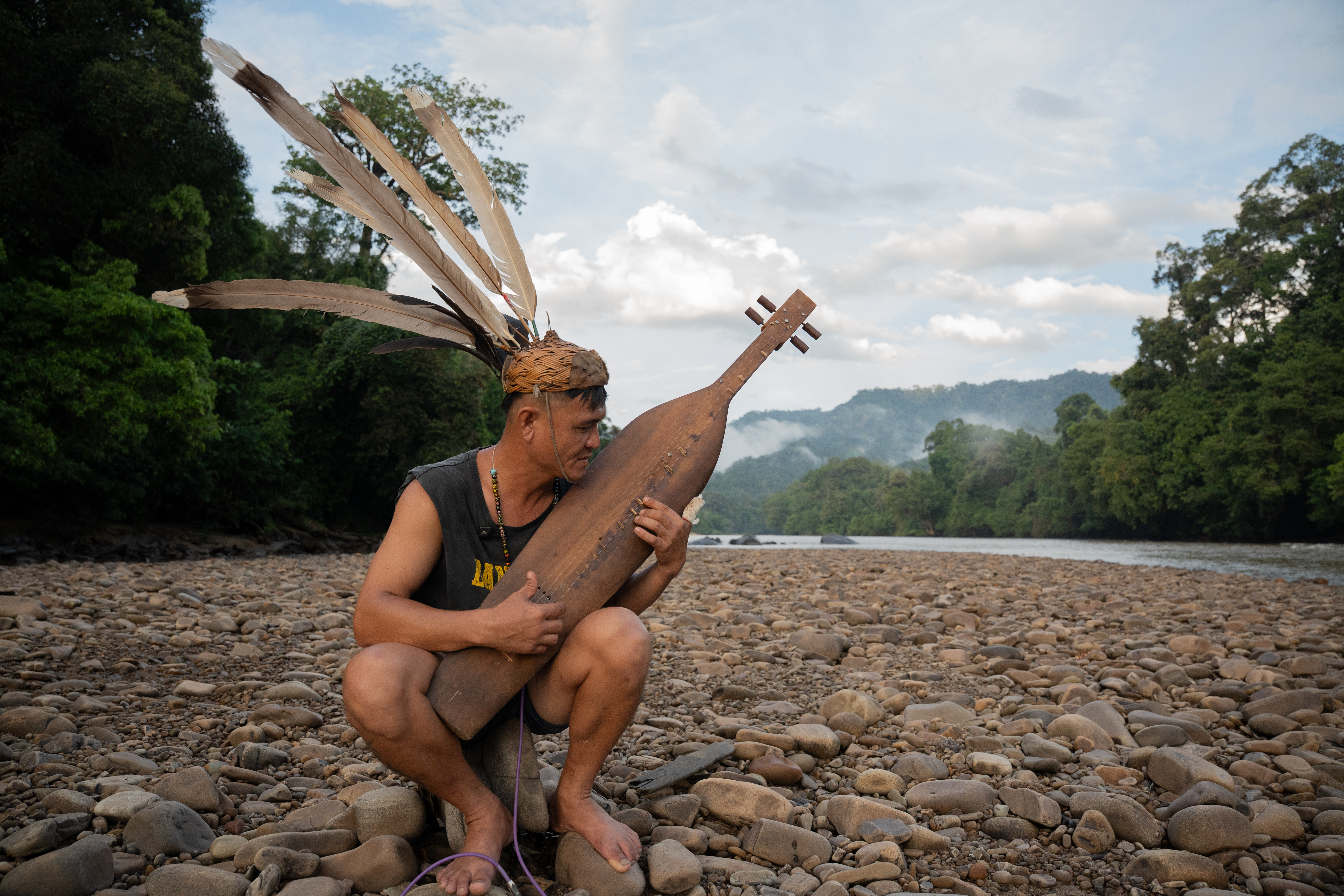 Robert Lenjau plays the Sapé, an instrument believed to have originated from Long Moh. The Adau wood used to make the instruments is becoming increasingly hard to find [Izzy Sasada/Al Jazeera]