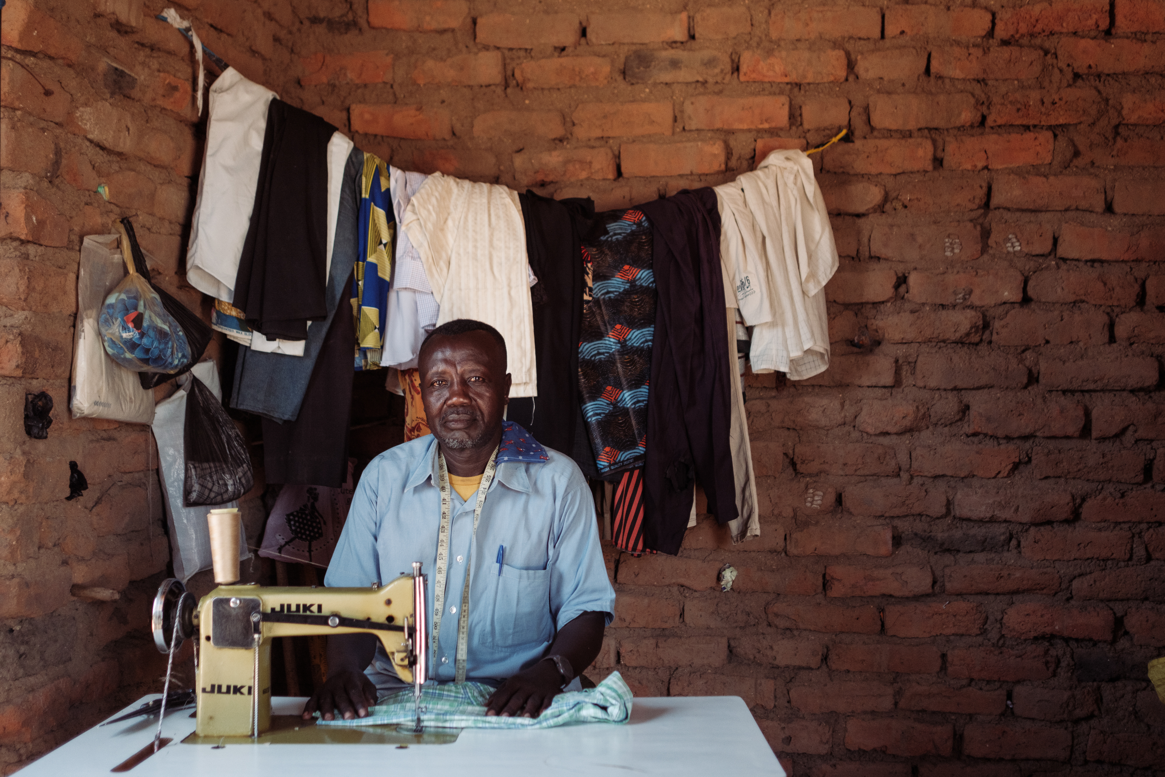 Ousman Nur Said, 53, sits with his sewing machine in his tailor shop where he has seen a significant increase in clients as large numbers of members of the RSF have appeared in the town since the signing of an alliance. He has been fixing uniforms damaged by fighting that is now relatively close by In Tongoli on April 22, 2025.