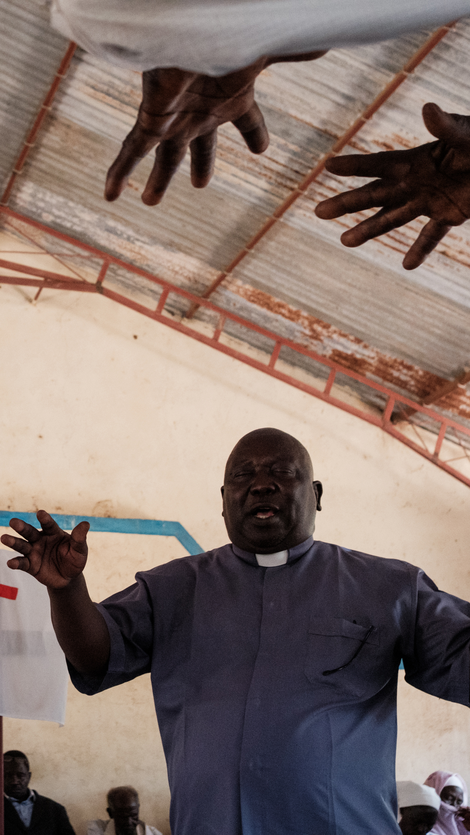 Pastor Yagub Ibrahim Tia blesses donated food during an Easter Sunday service In Kauda on April 20, 2025 [Guy Peterson/Al Jazeera]