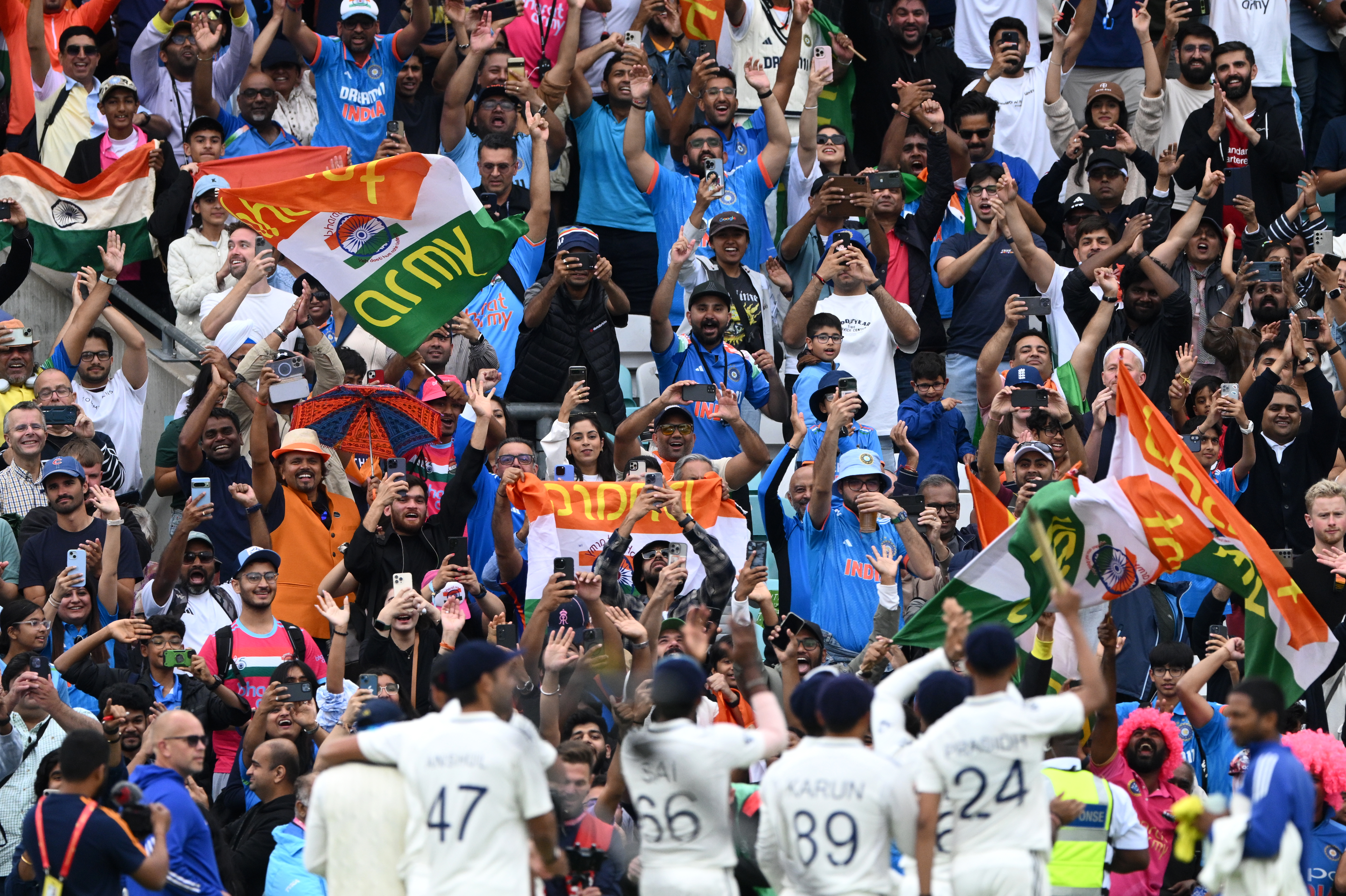 Fans of India celebrate their team's victory with the players on day five of the fifth Test