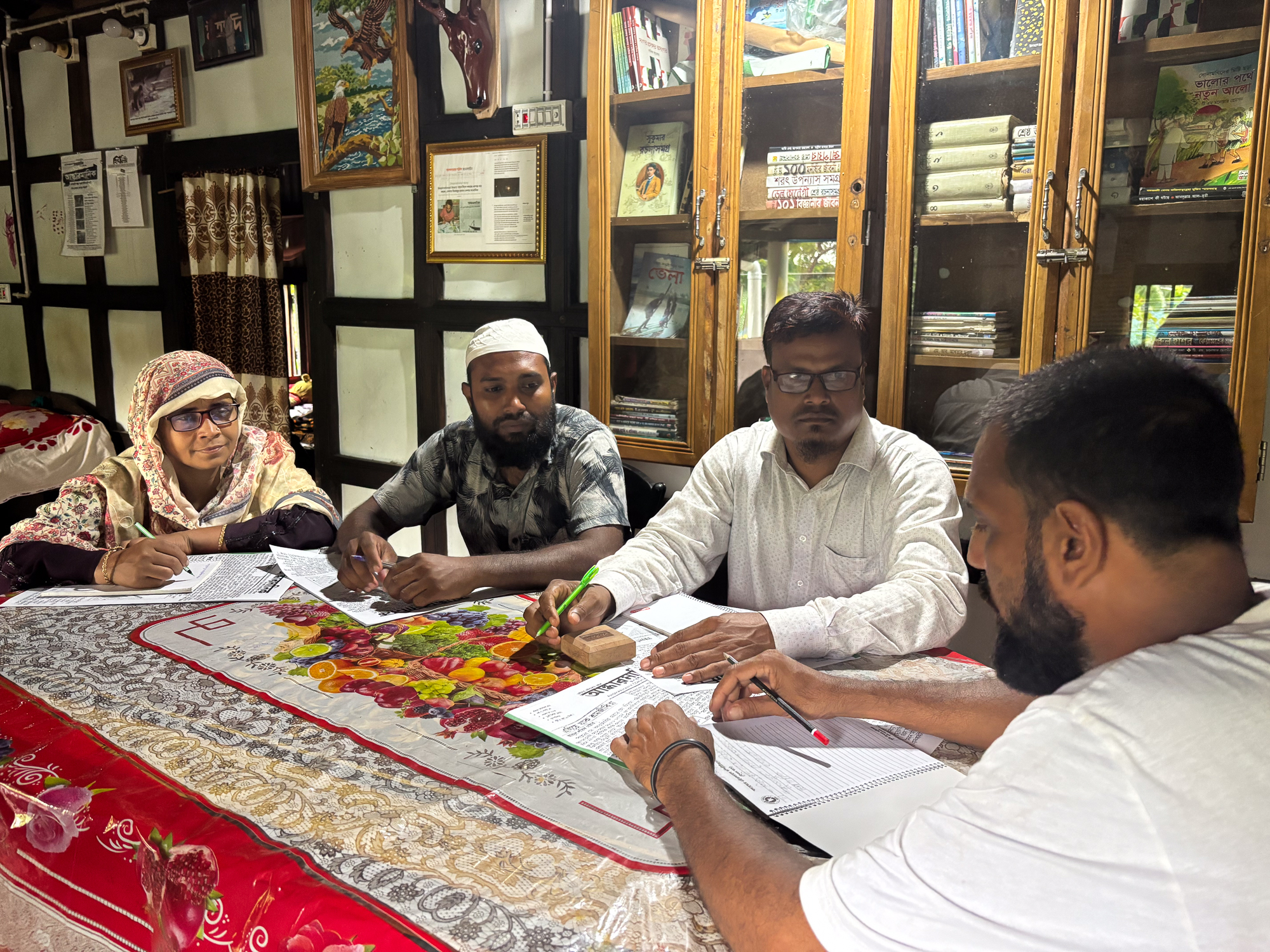 (L-R) Russiah Begum, Nazrul Islam Bilal, Abdul Latif and editor-in-chief Hasan Parvez meet to discuss the new issue of Andharmanik, a handwritten community newspaper [Diwash Gahatraj/Al Jazeera]
