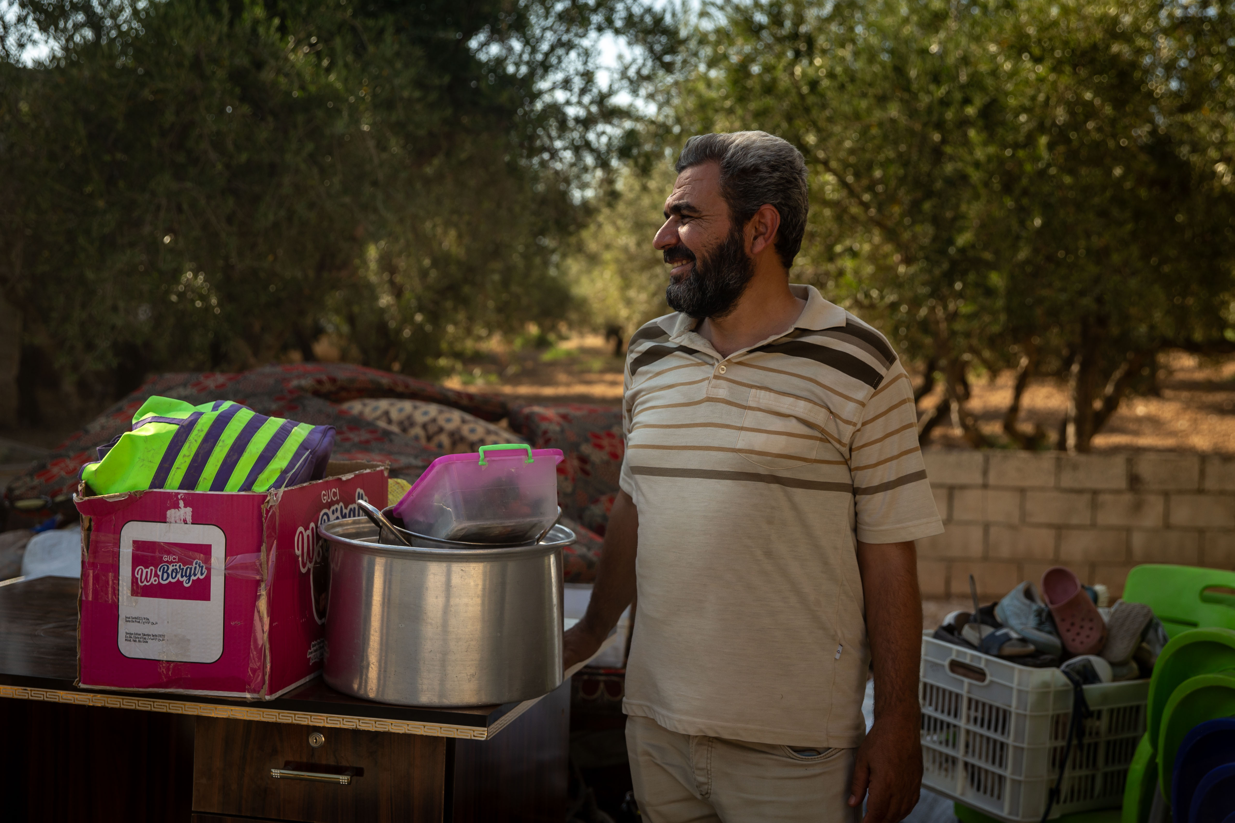 Middle-aged man looks to the distance with household goods gathered around him