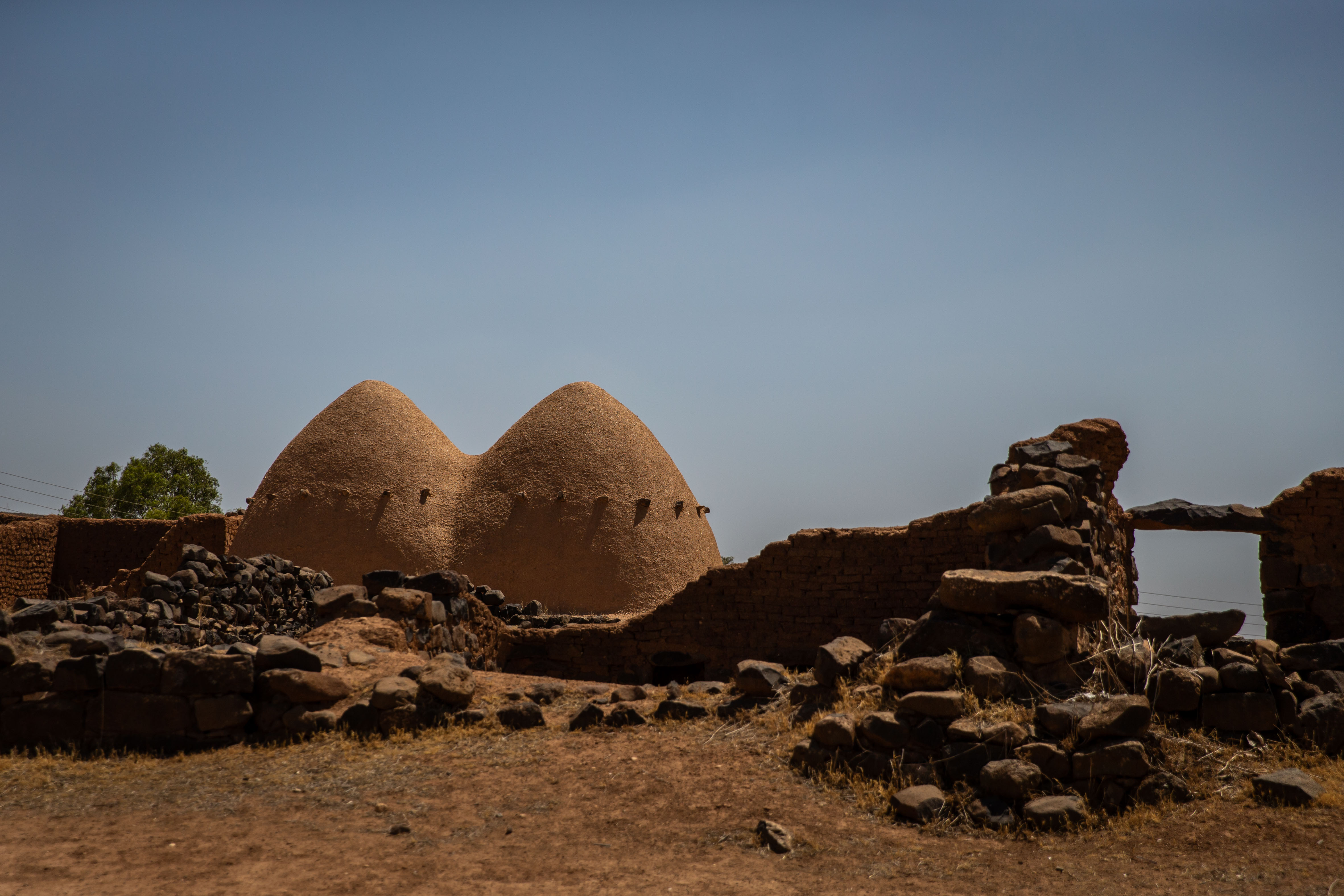Two terracotta domes stand next to an old graveyard