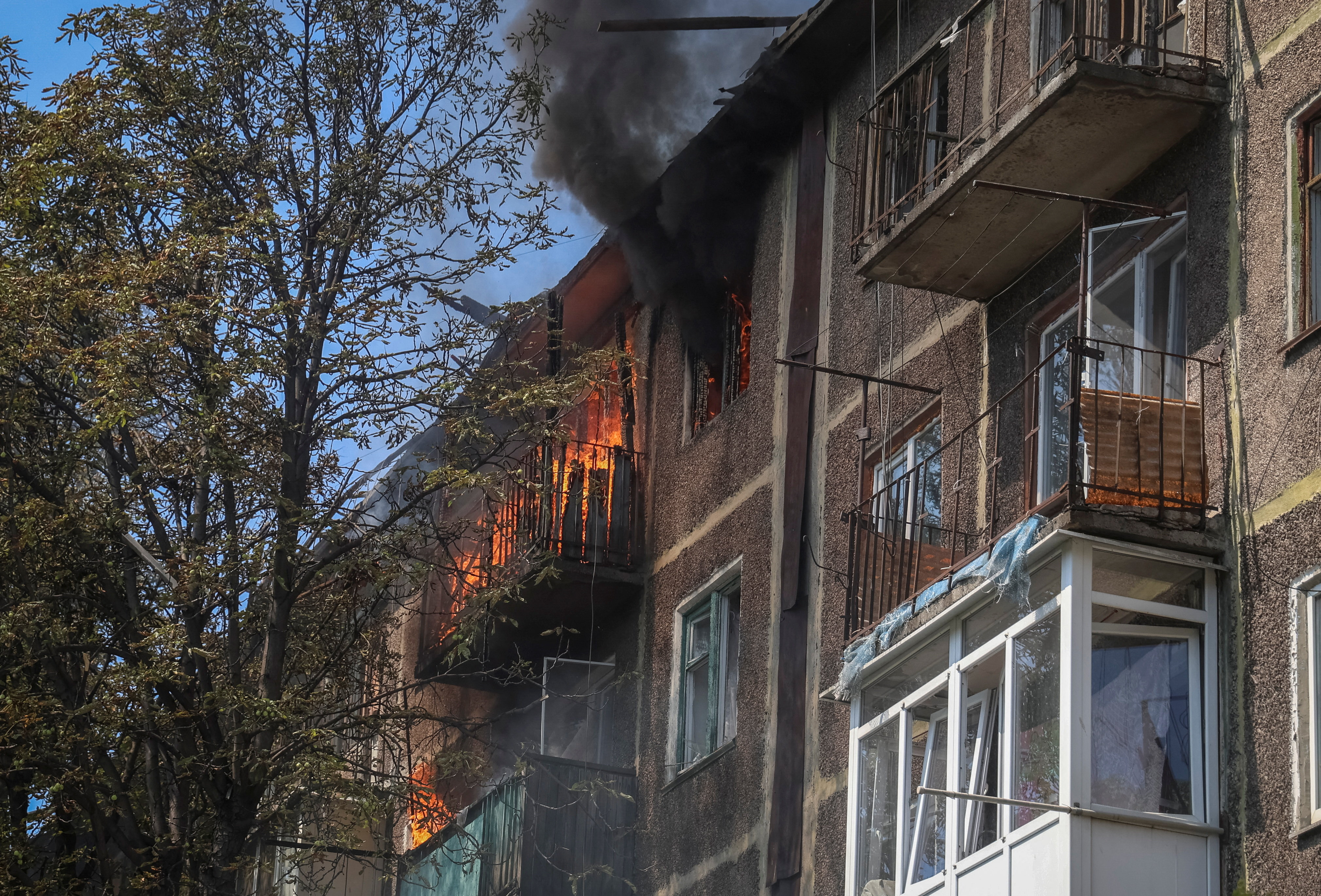 Smoke rises as fire burns at the site of an apartment building hit by Russian drone strike, amid Russia's attack on Ukraine, in the town of Bilozerske in Donetsk region, Ukraine August 10, 2025. REUTERS/Oleksandr Ratushniak