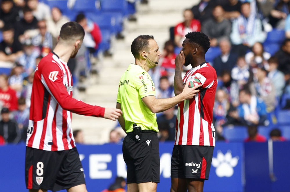 Athletic Club Bilbao's forward Inaki Williams (R) chats with referee Del Cerro Grande (C) during their LaLiga game at RCDE Stadium in Cornella de Llobregat, Barcelona