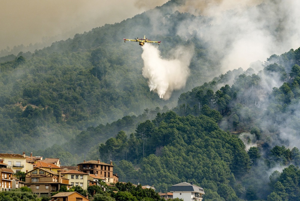 epa12272360 A firefighting aircraft tackles a wildfire in the municipality of El Arenal, central Spain, 30 July 2025. The advance of a forest fire in Avila province has forced the municipality of El Arenal into lockdown, amid an increase in active outbreaks on the Iberian Peninsula, due to the heatwave, wind, and low humidity. EPA/RAUL SANCHIDRIAN