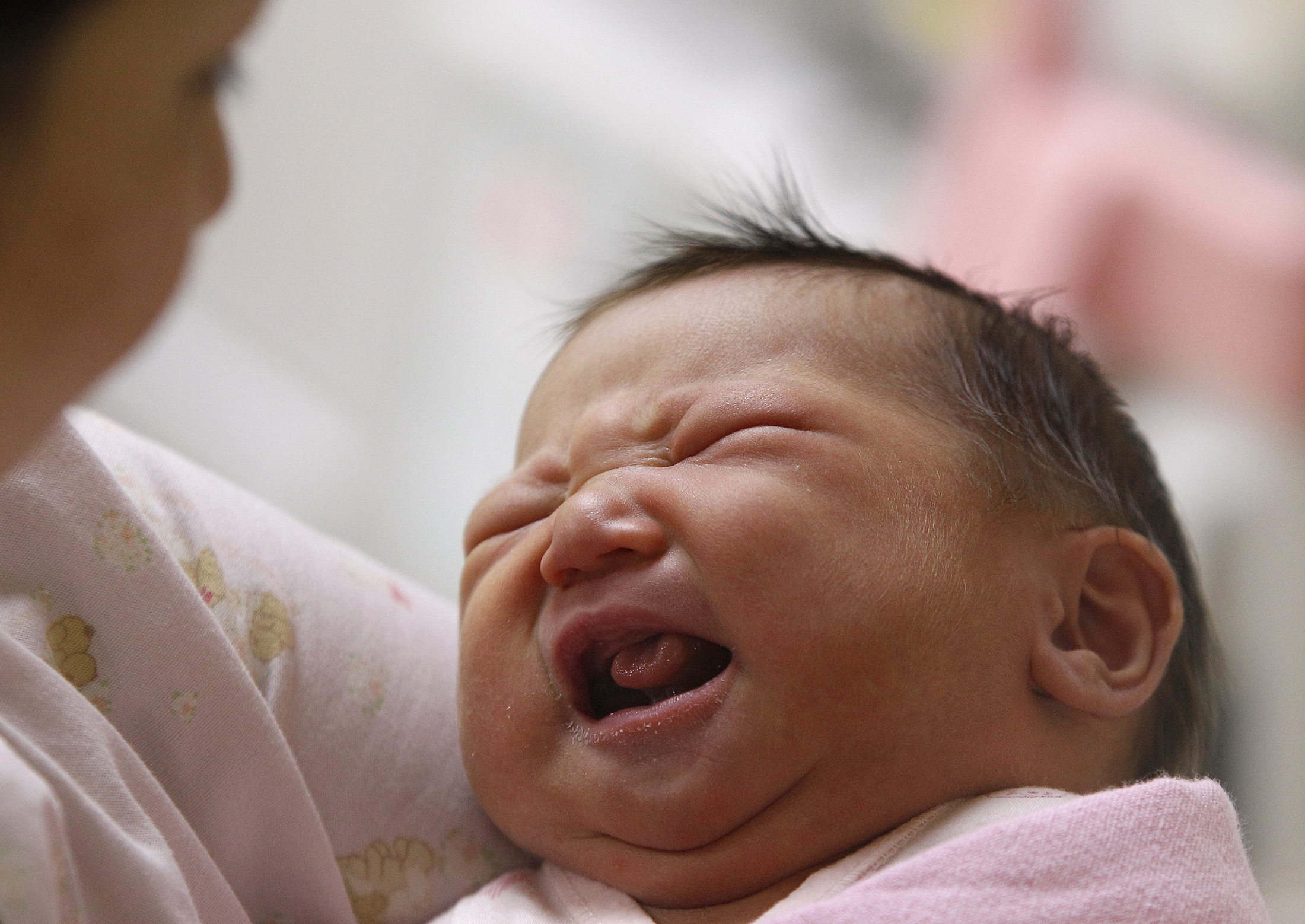 A nurse looks after a three-day-old baby inside the maternity ward of a hospital in Taiwan [Pichi Chuang/Reuters]